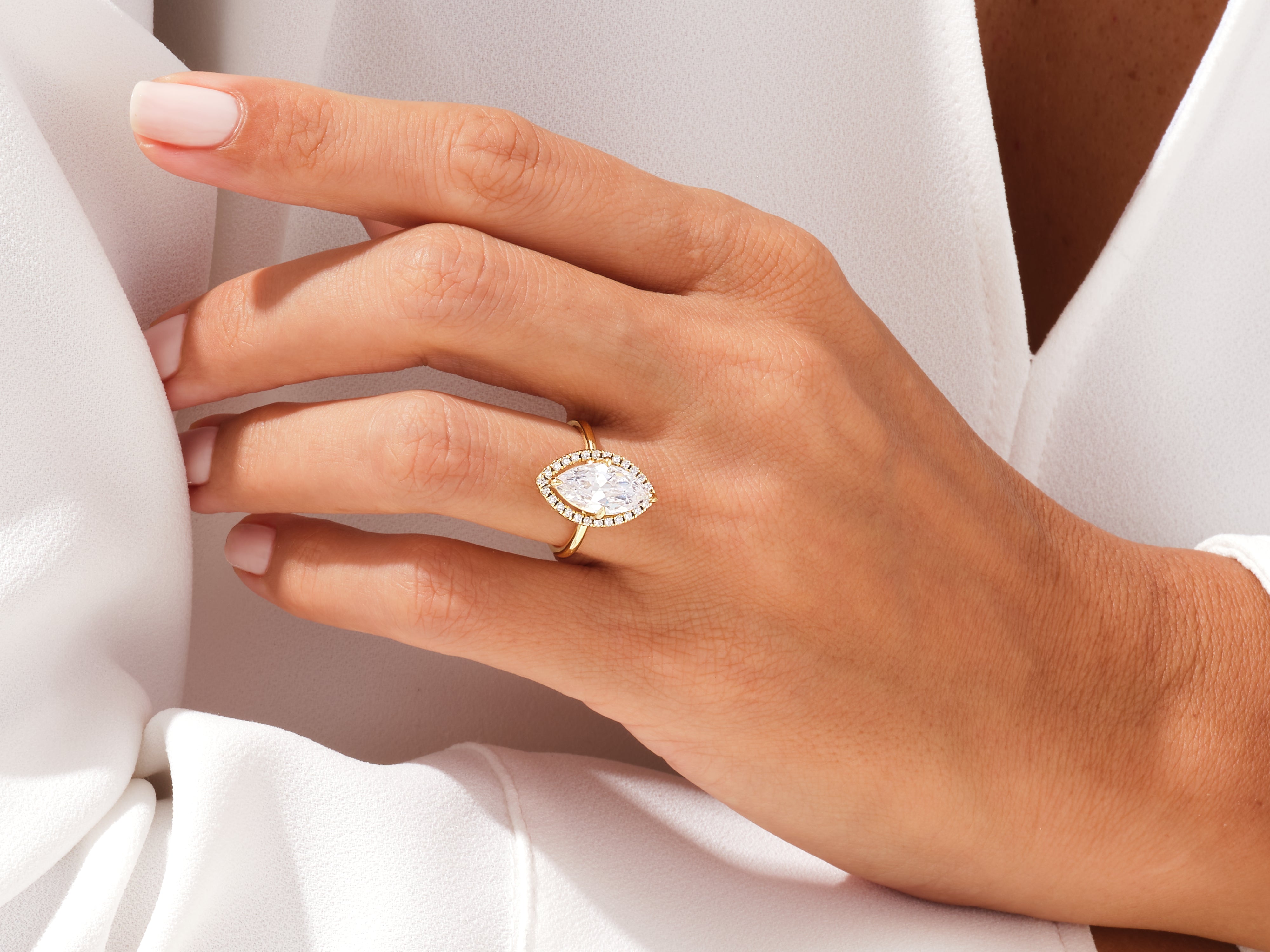 Marquise diamond engagement ring with halo on hand