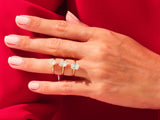 Gold rings with emerald-cut diamonds on a hand