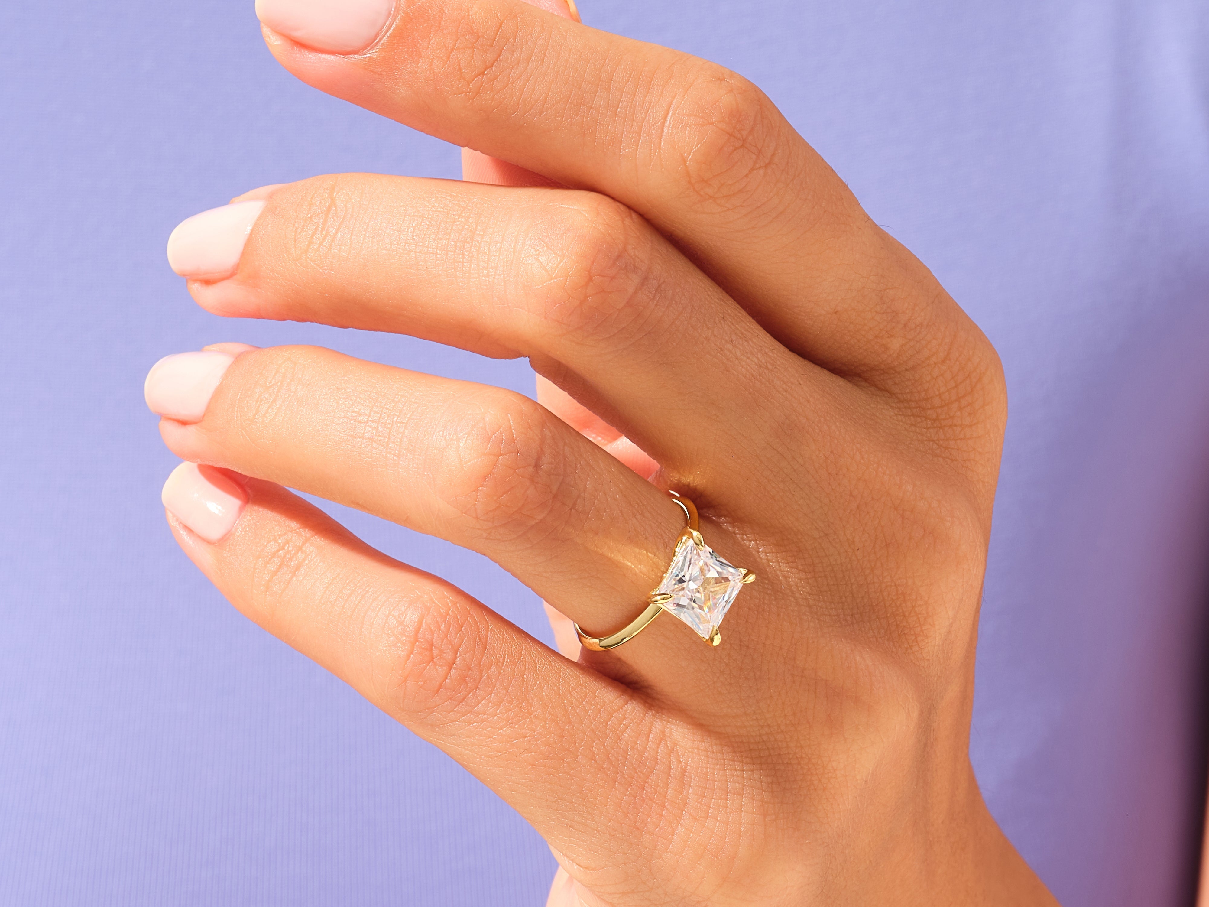 Gold ring with princess cut diamond on hand