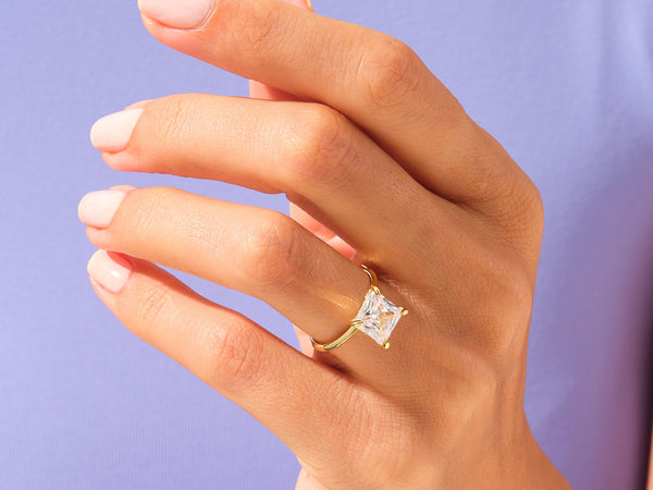 Gold ring with princess cut diamond on hand