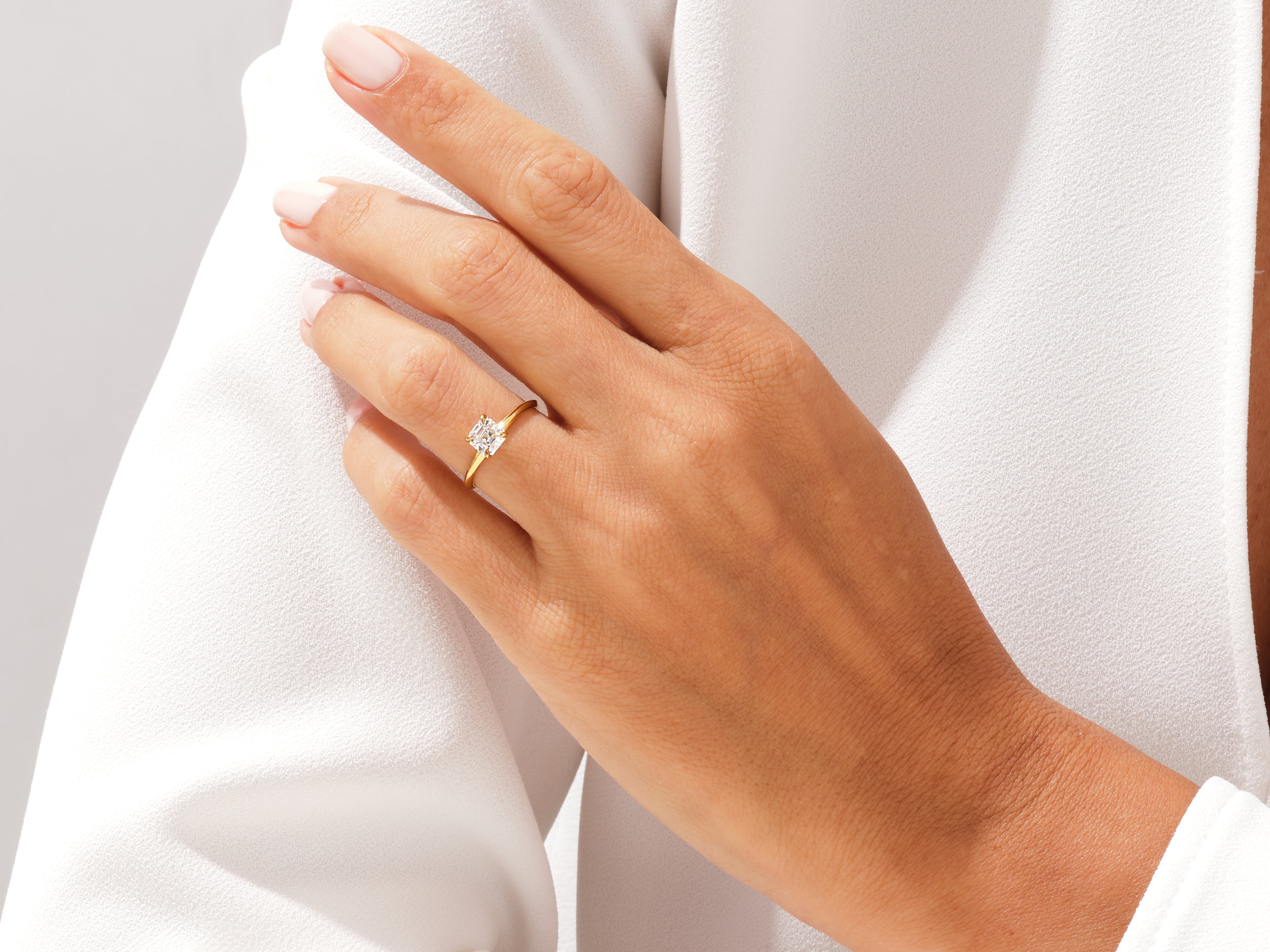 Gold diamond ring on a woman's finger, jewelry product photography