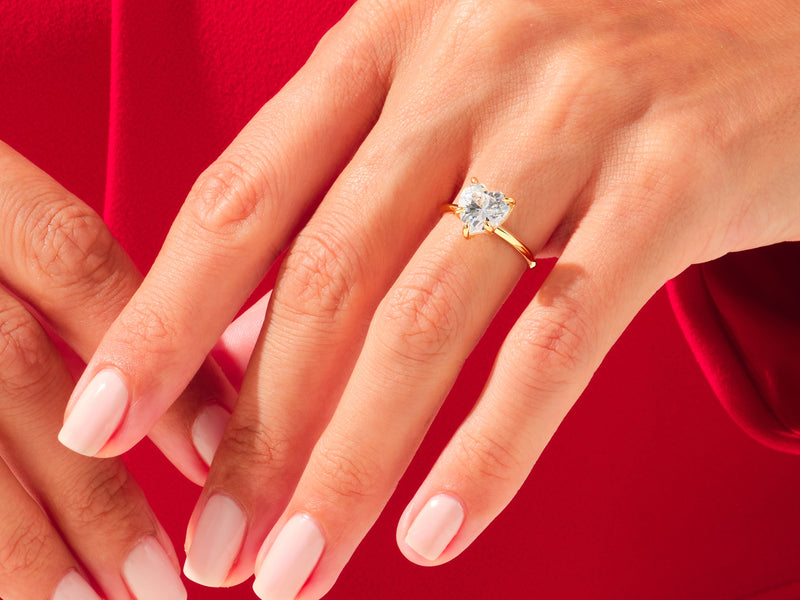 Gold ring with heart-shaped diamond on a hand, jewelry