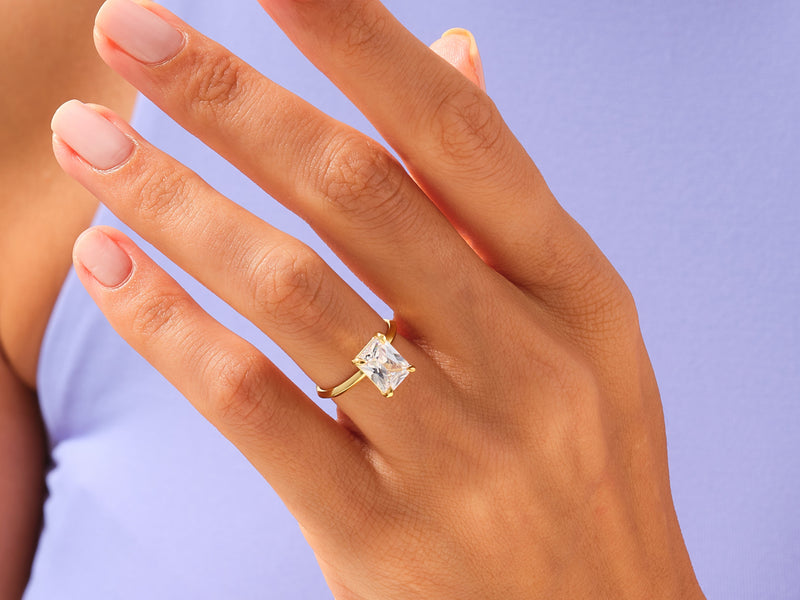 Gold ring with princess cut diamond on hand