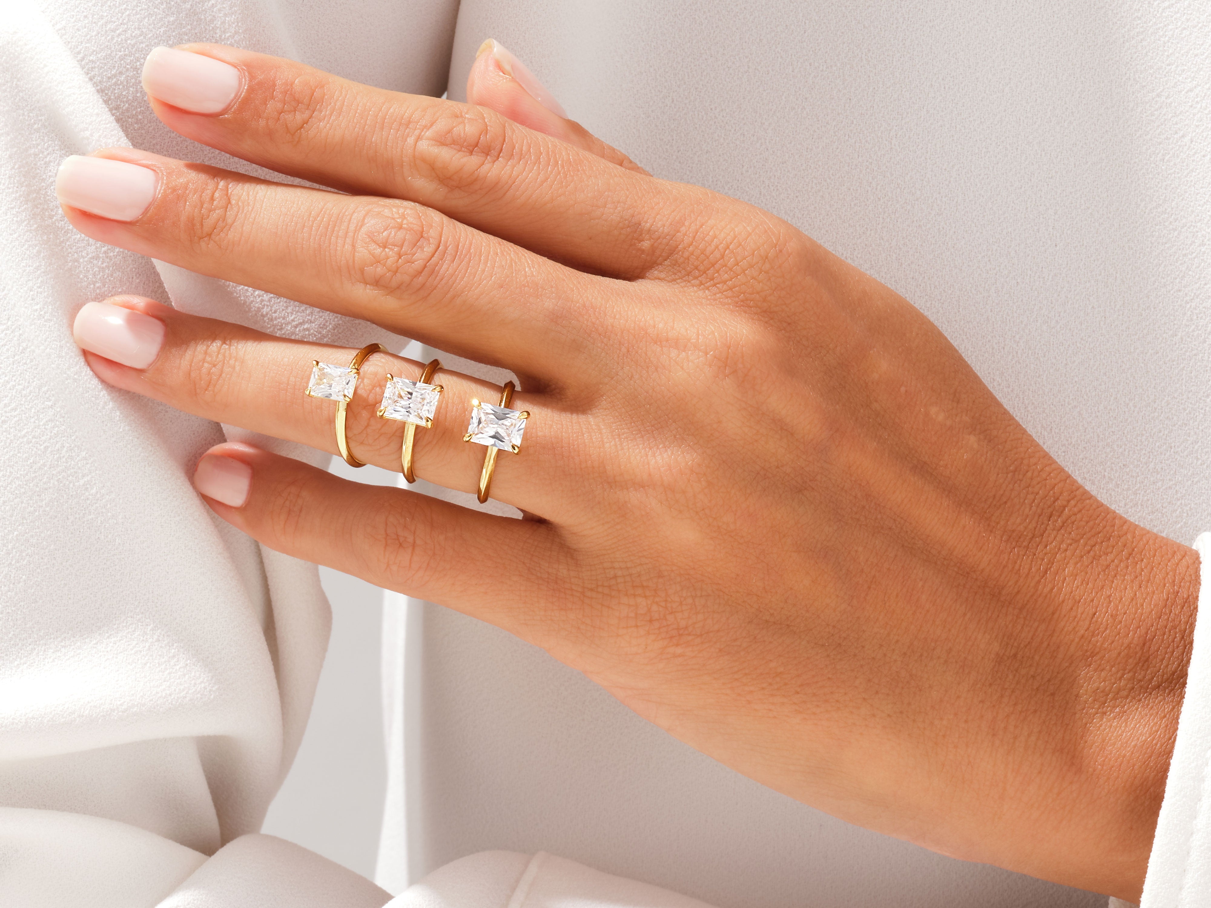 Three elegant gold rings with baguette diamonds on a hand