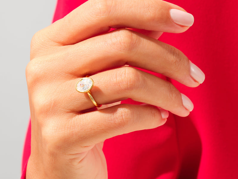 Gold ring with oval diamond on a hand