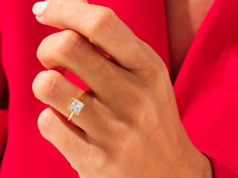 Gold ring with princess cut diamond on hand