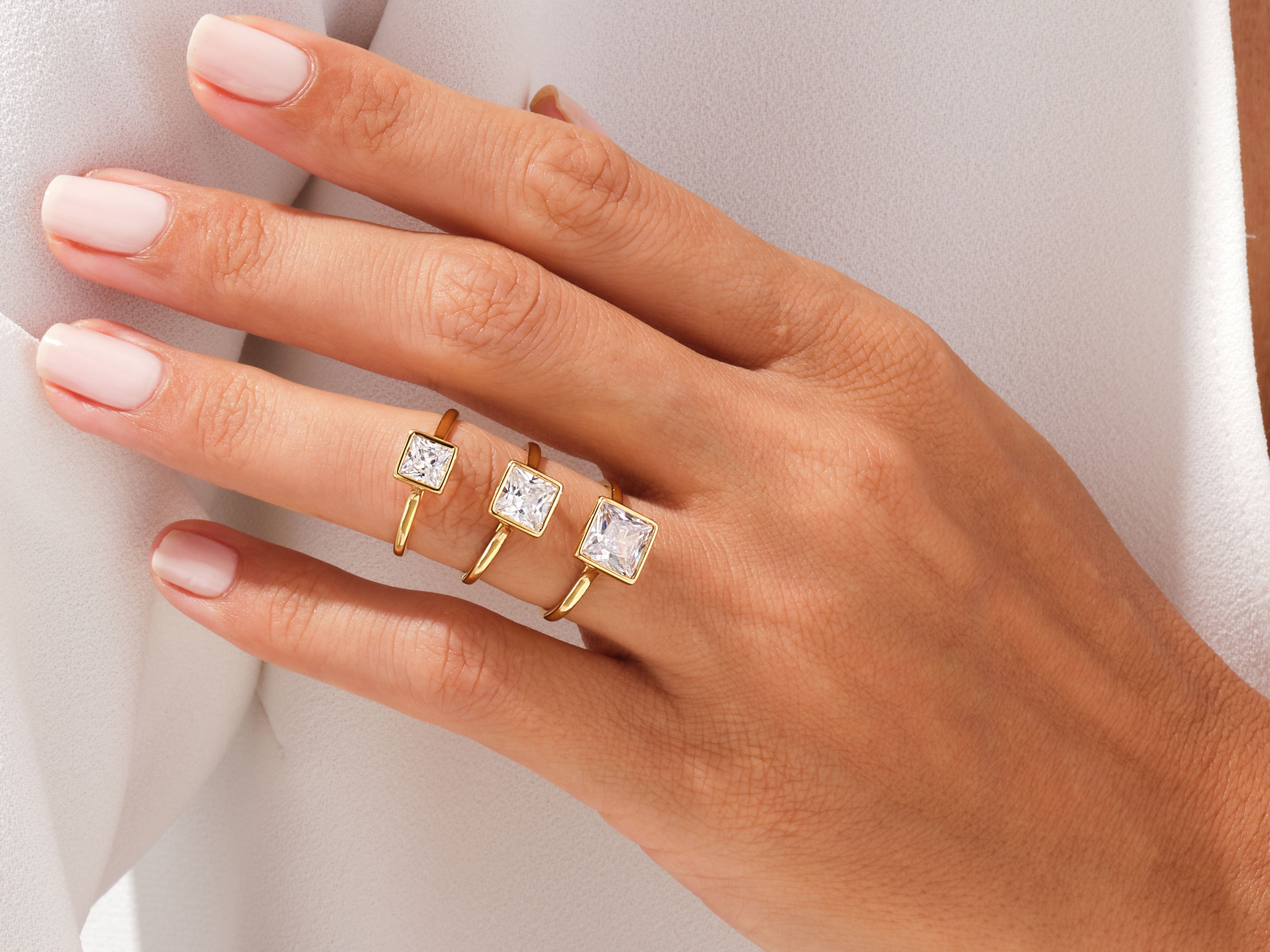 Gold rings with square diamonds on a hand