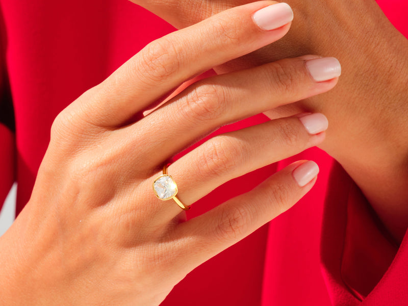 Gold ring with cushion-cut diamond on hand, jewelry photography