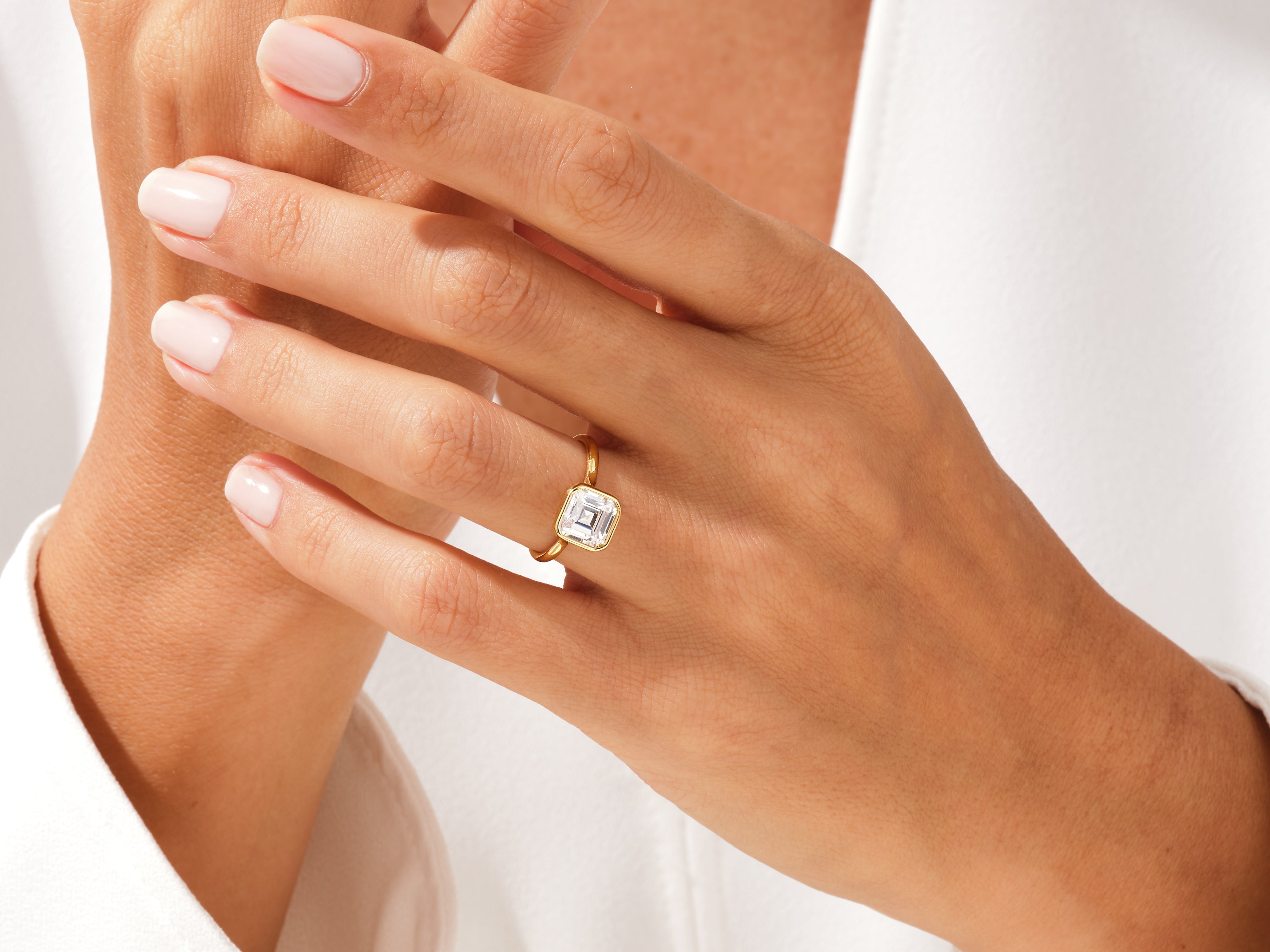 Gold ring with emerald-cut diamond on hand