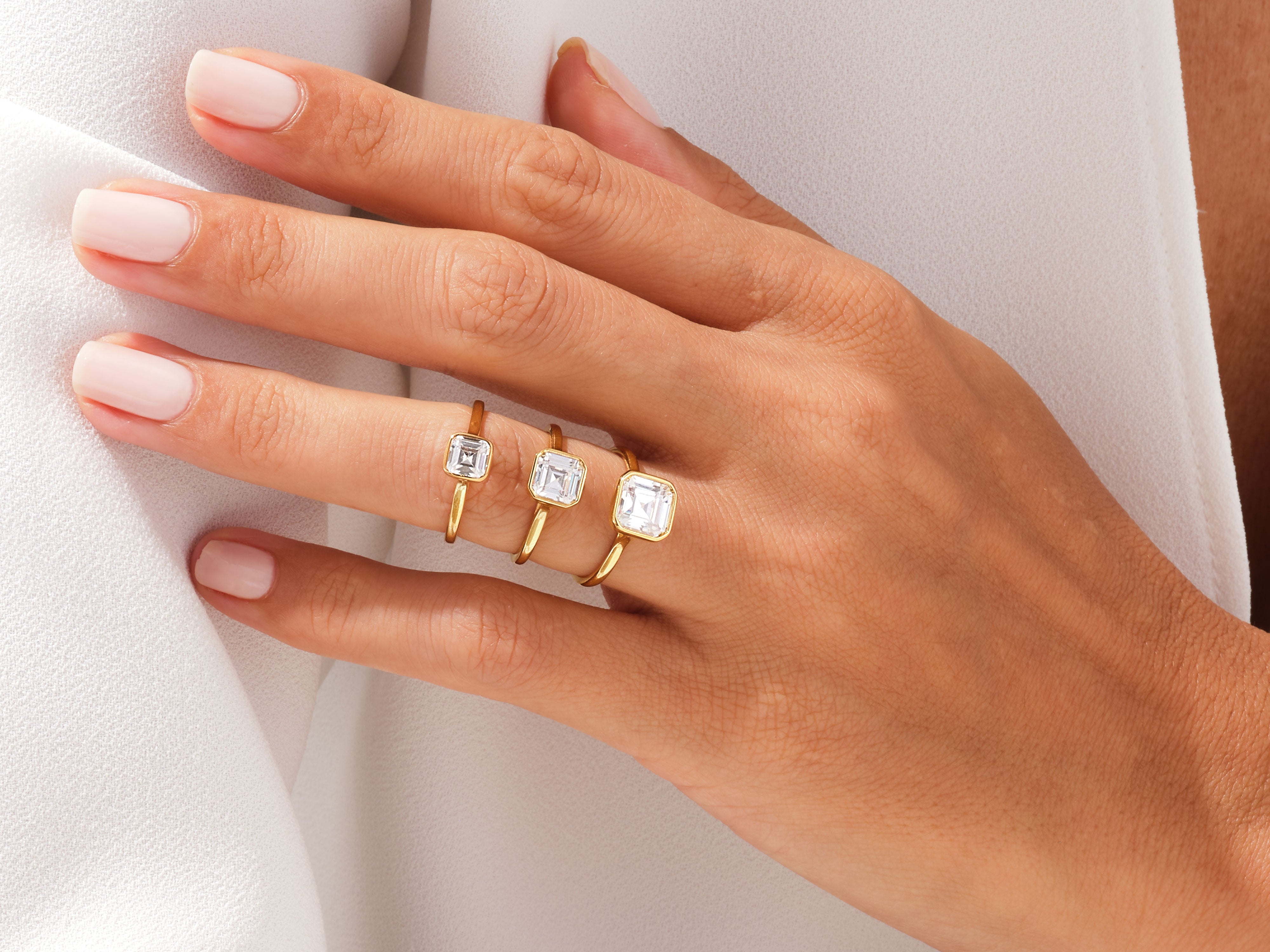 Elegant gold rings with square-cut diamonds on a hand
