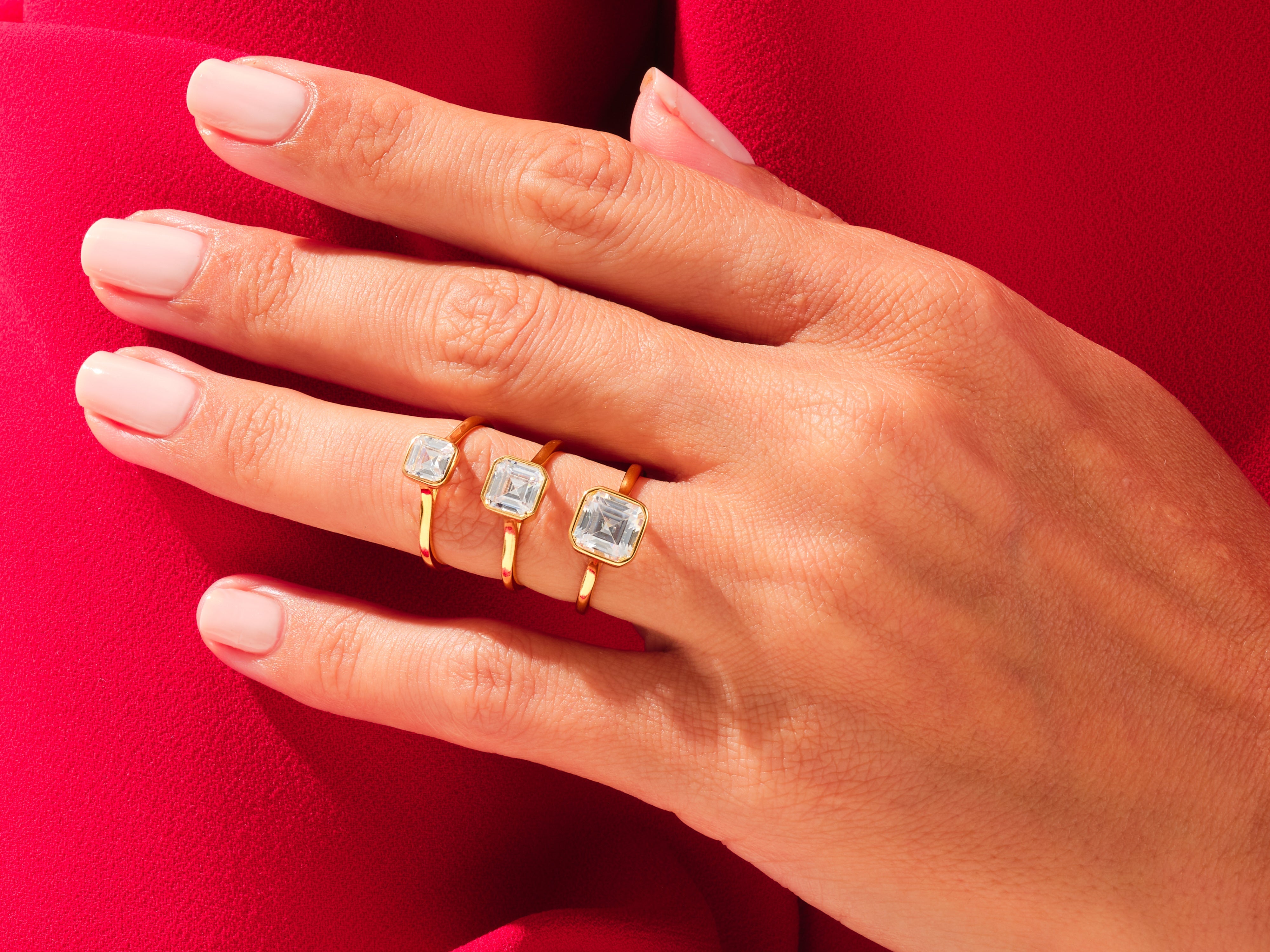 Gold rings with square cut diamonds on a hand