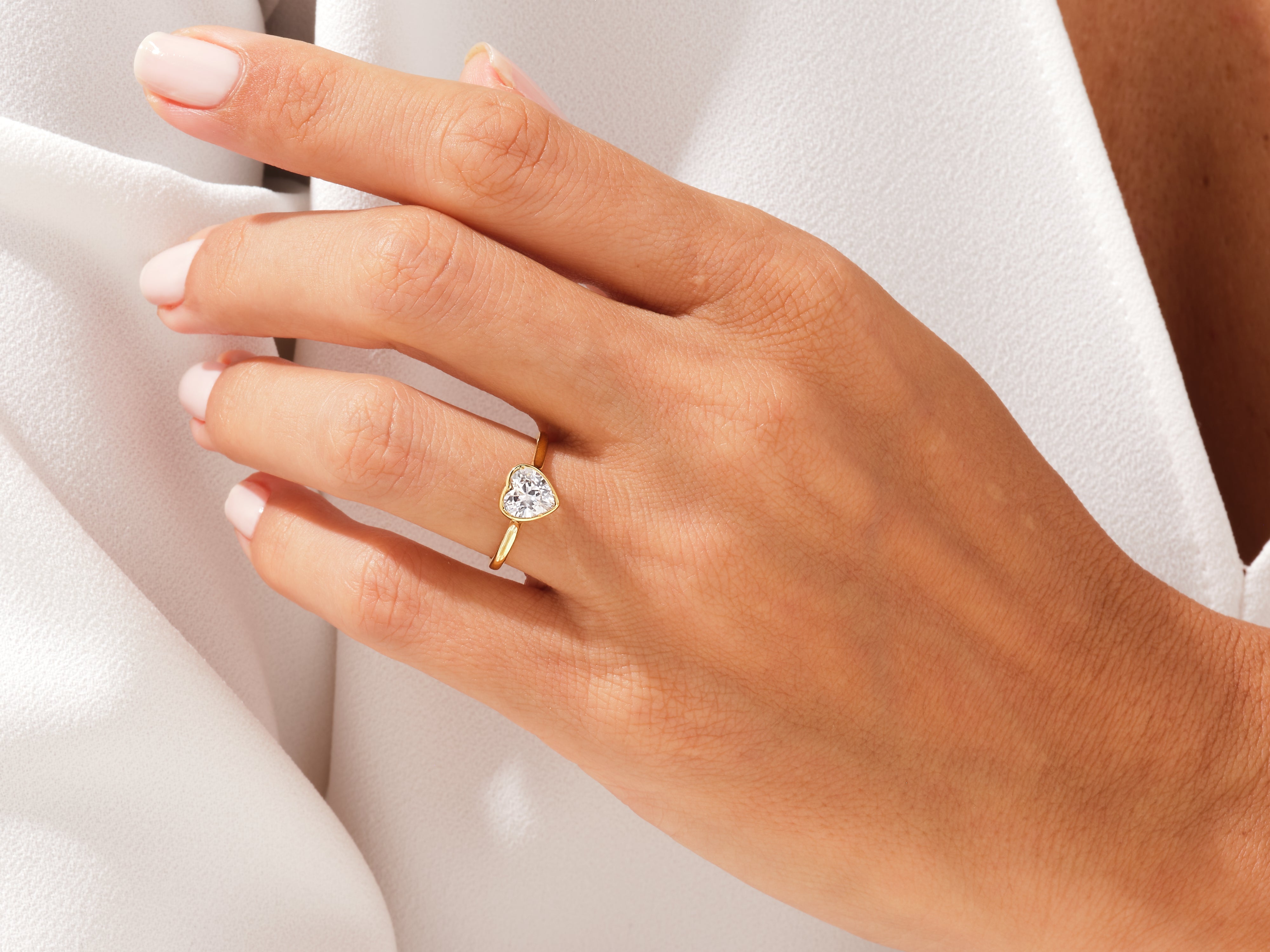 Gold heart diamond ring on a woman's hand