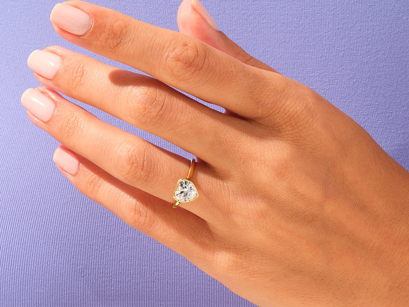Gold heart ring with diamond on hand