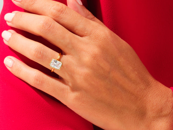 Gold ring with emerald cut diamond on hand