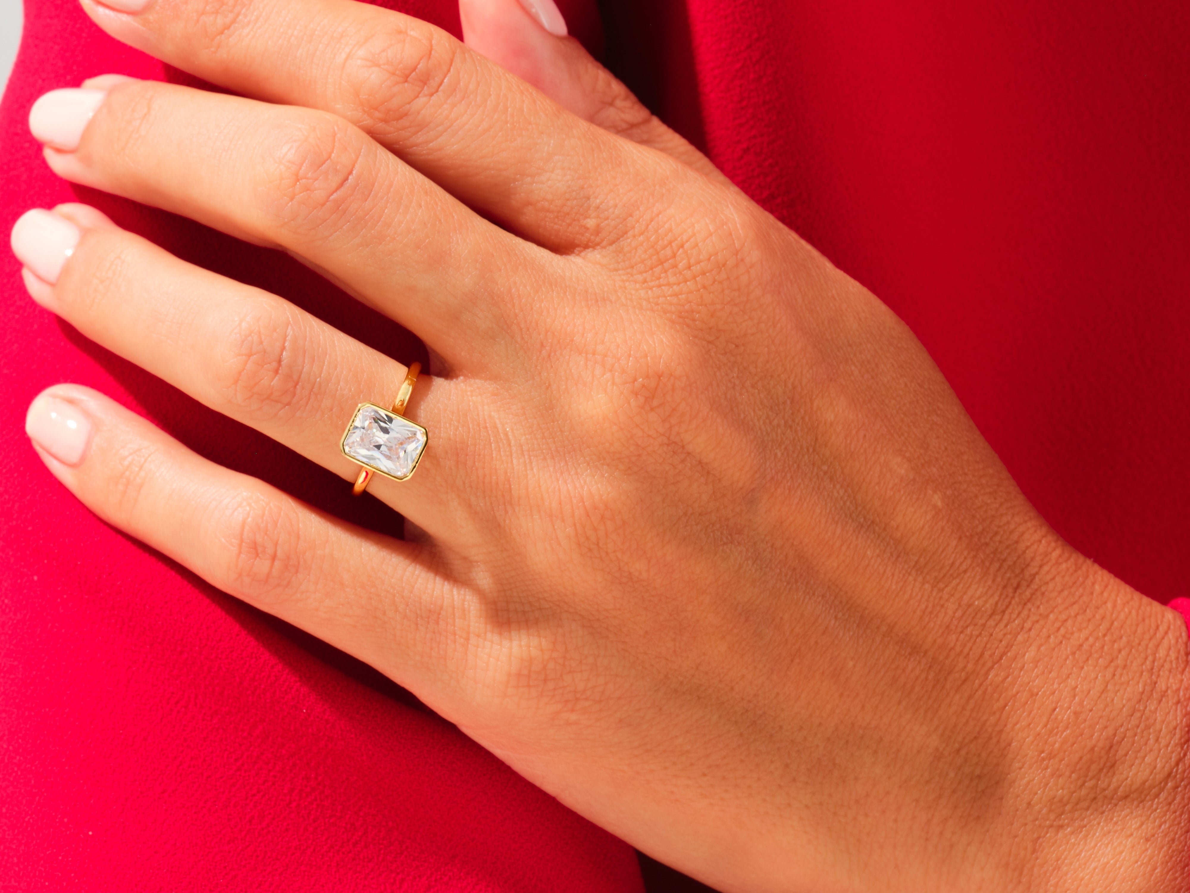 Gold ring with emerald cut diamond on hand