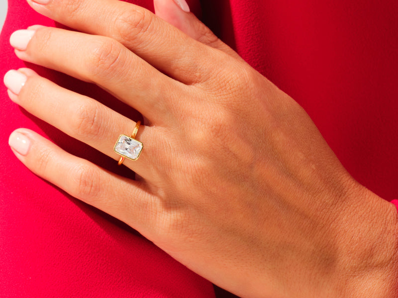 Gold ring with emerald cut diamond on hand