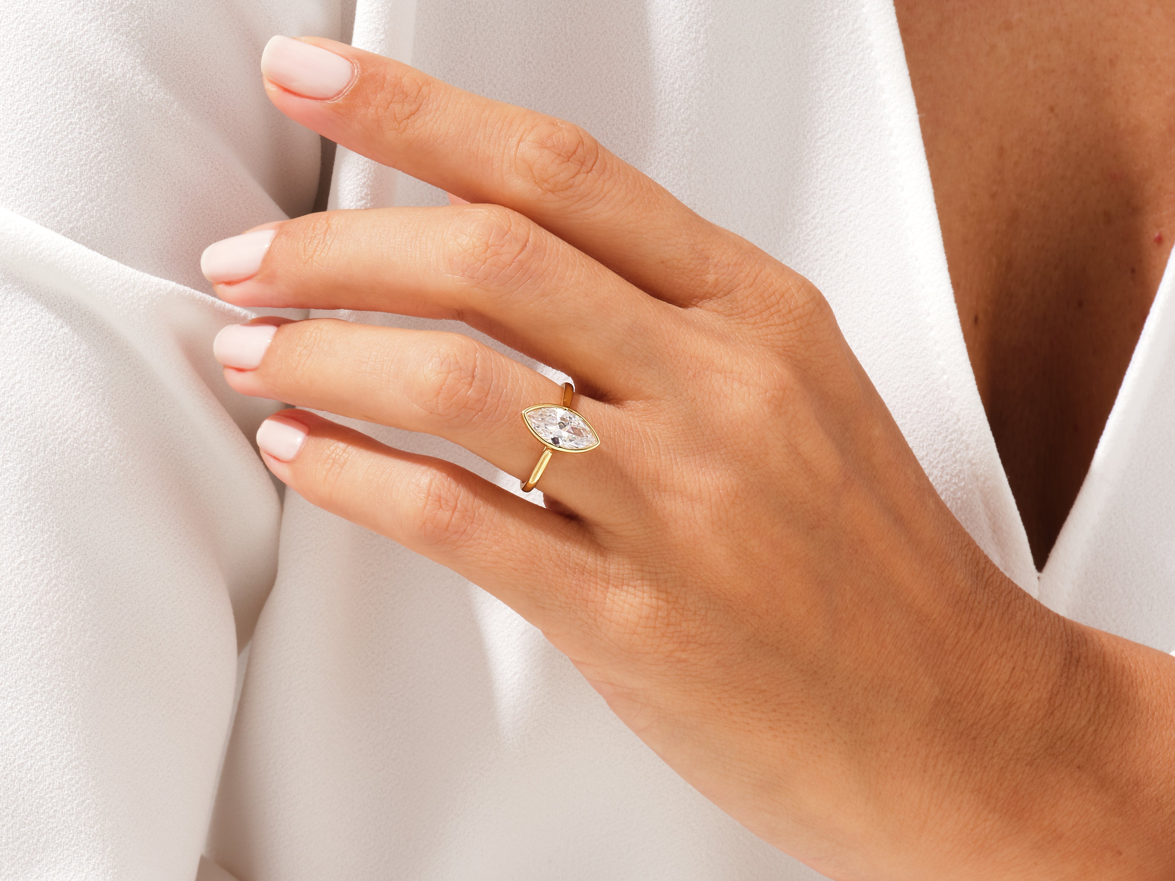 Gold marquise diamond engagement ring on a woman's hand