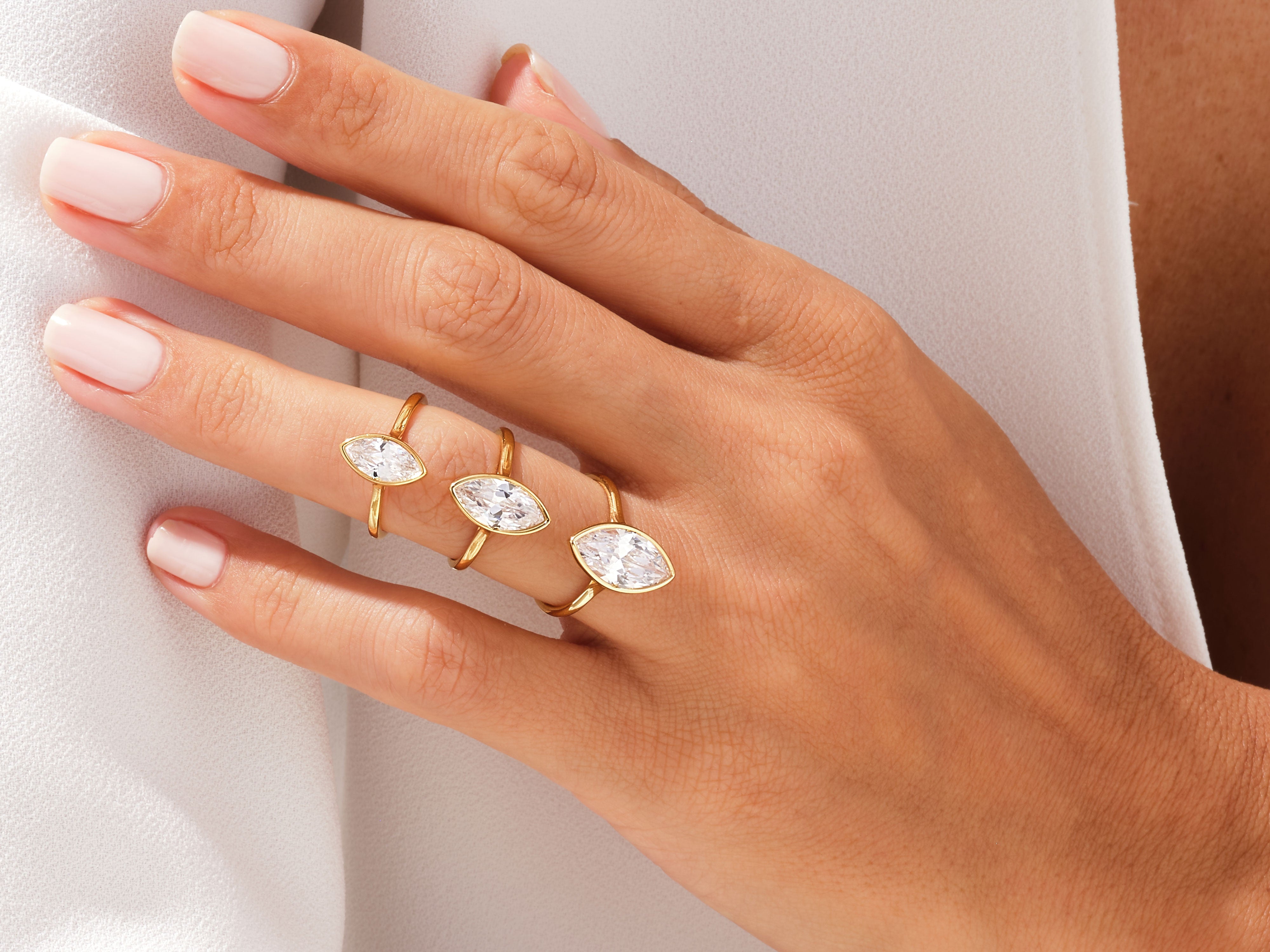 Gold marquise diamond rings on a hand