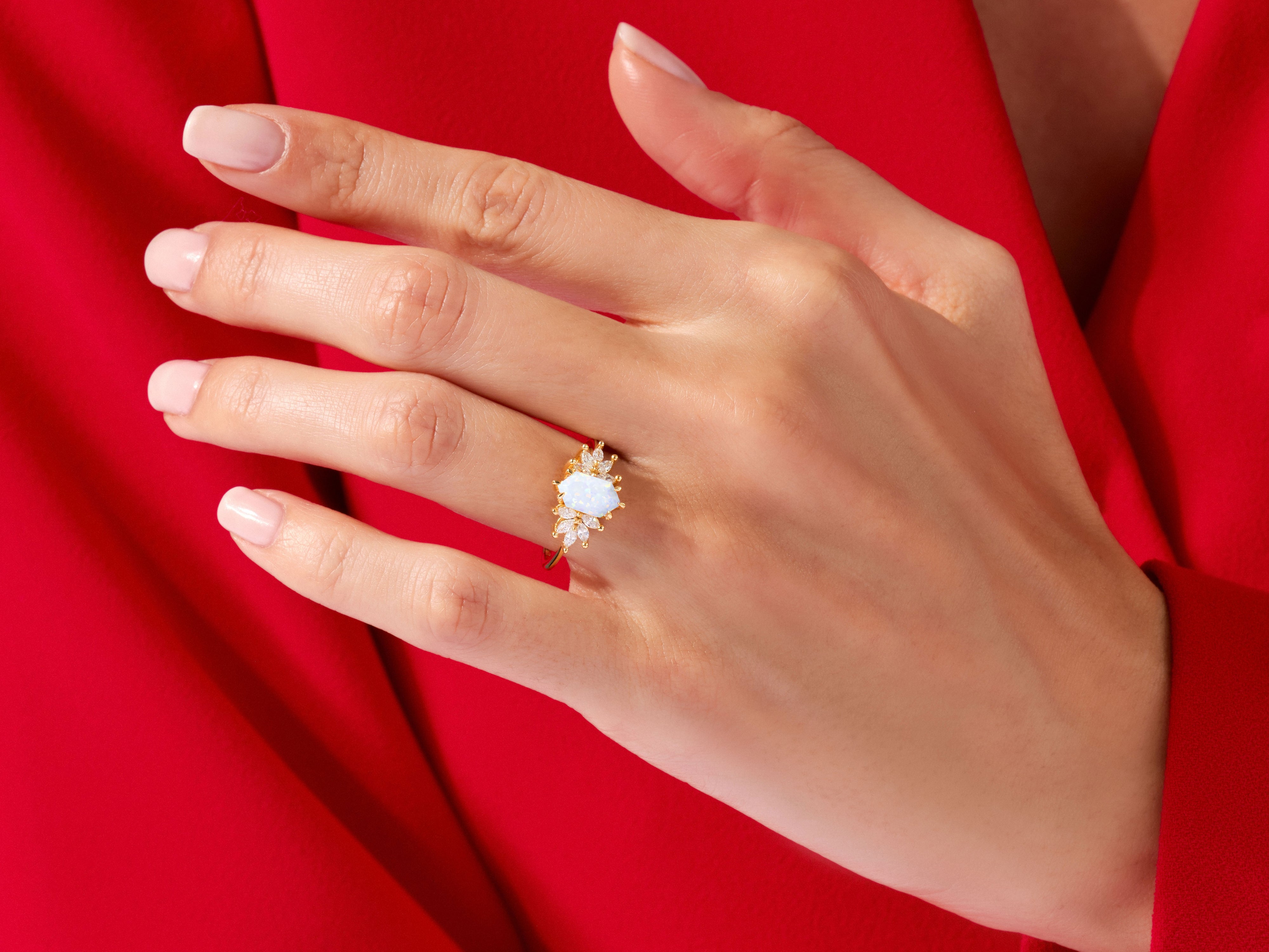 Gold opal ring with diamonds on a hand