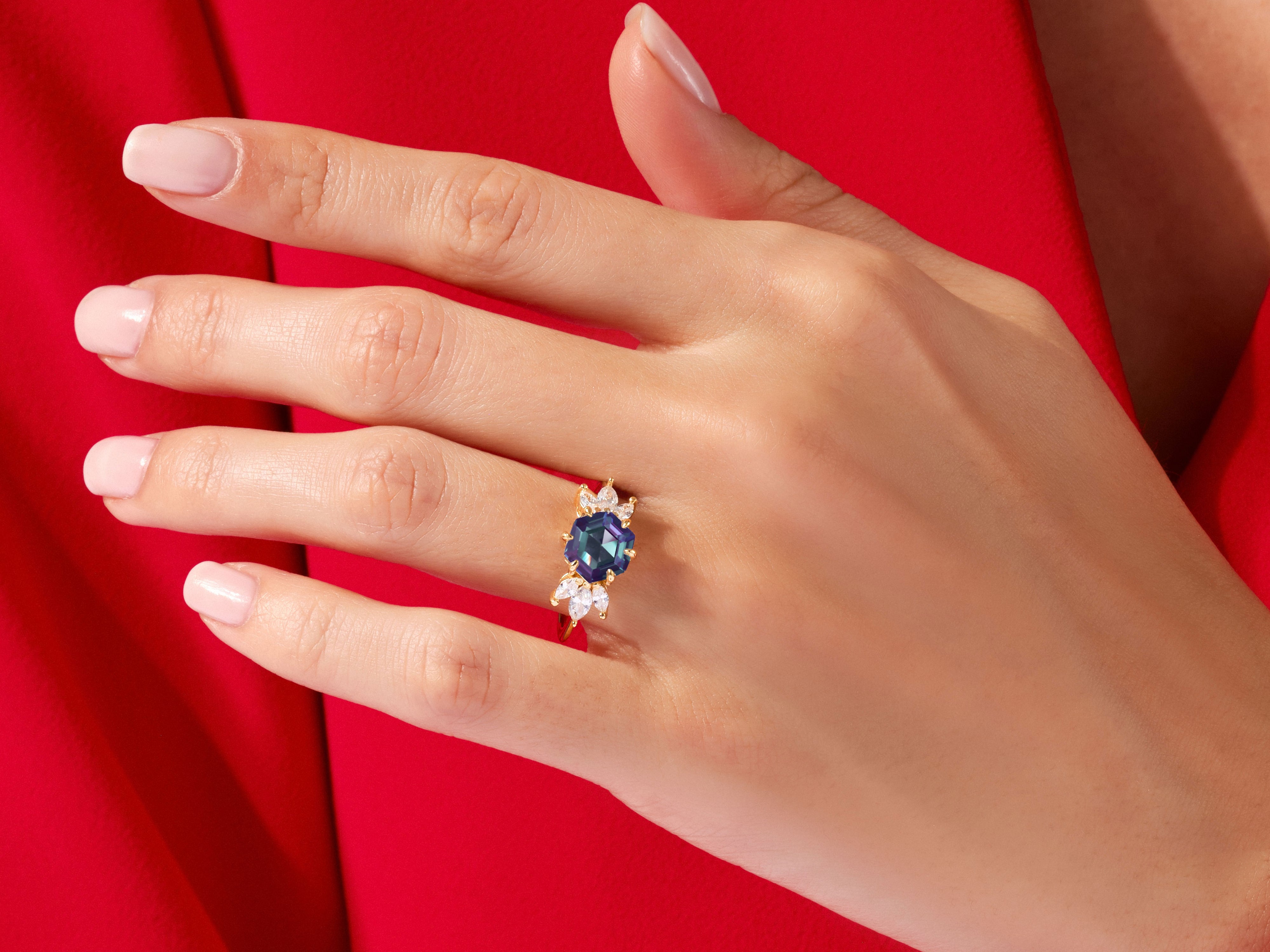 Gold ring with blue gemstone and diamonds on a hand