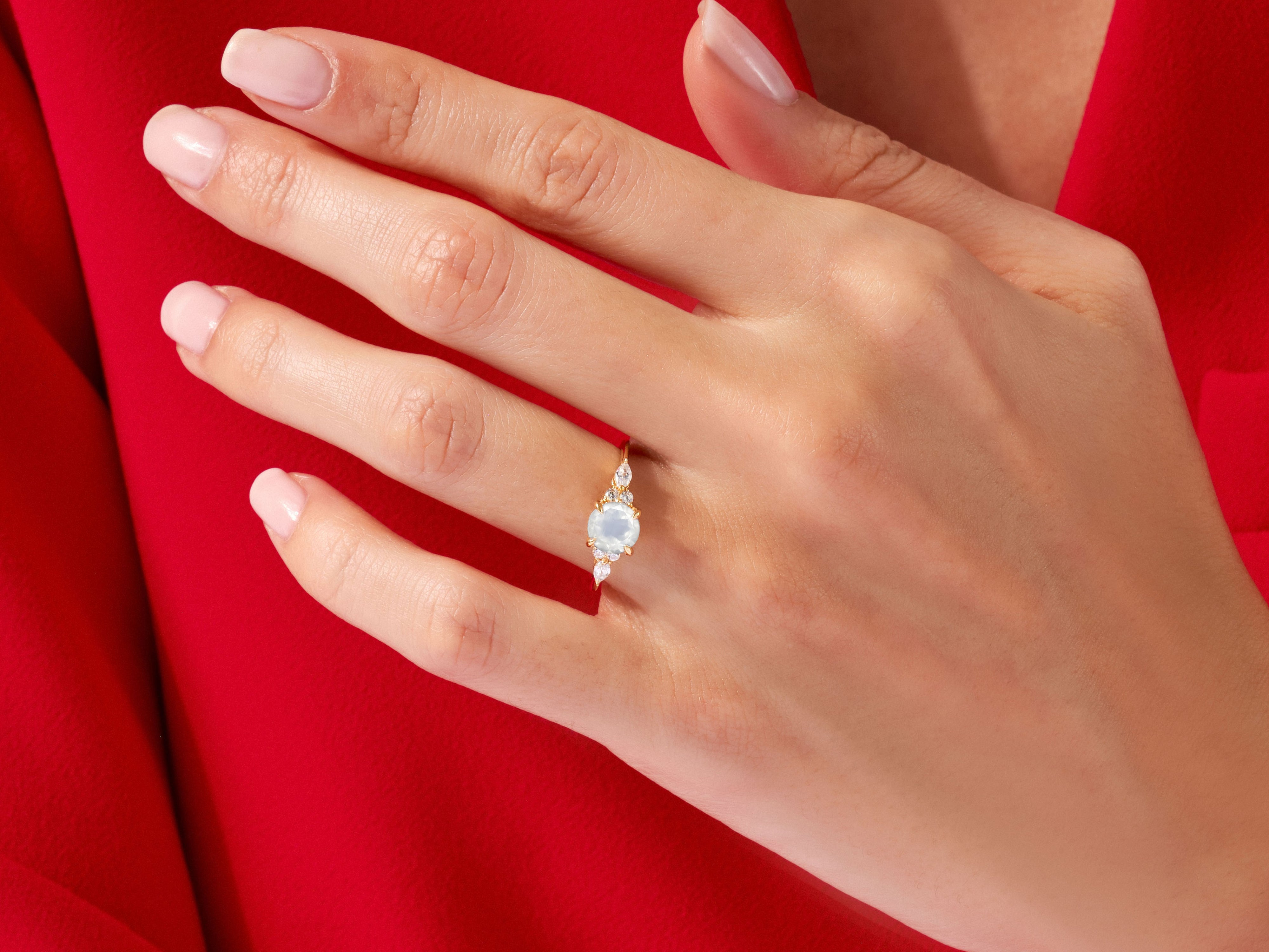 Gold ring with opal and diamonds on a hand