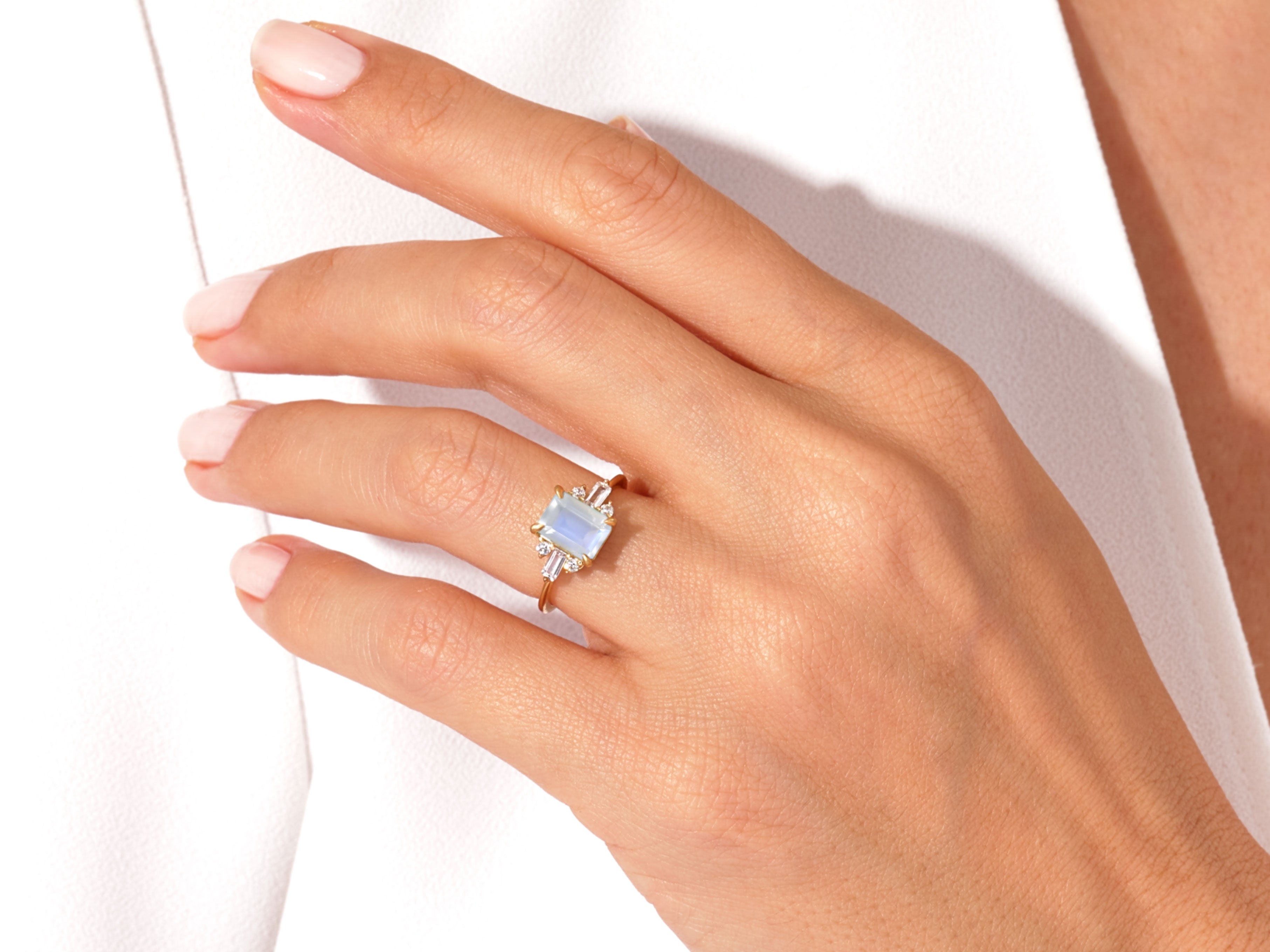 Gold ring with rectangular moonstone and baguette diamonds on hand