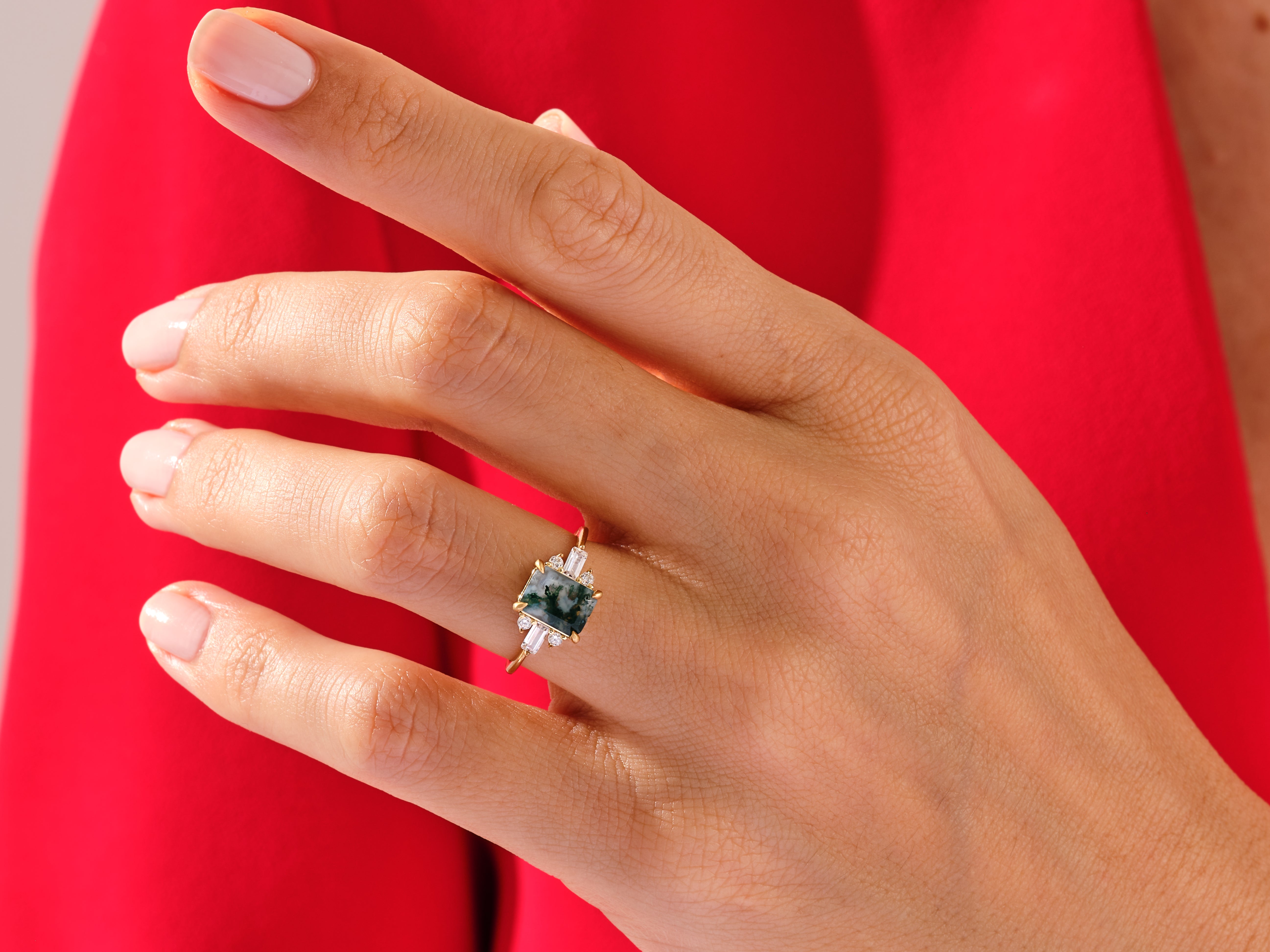 Moss agate ring with diamonds on a hand