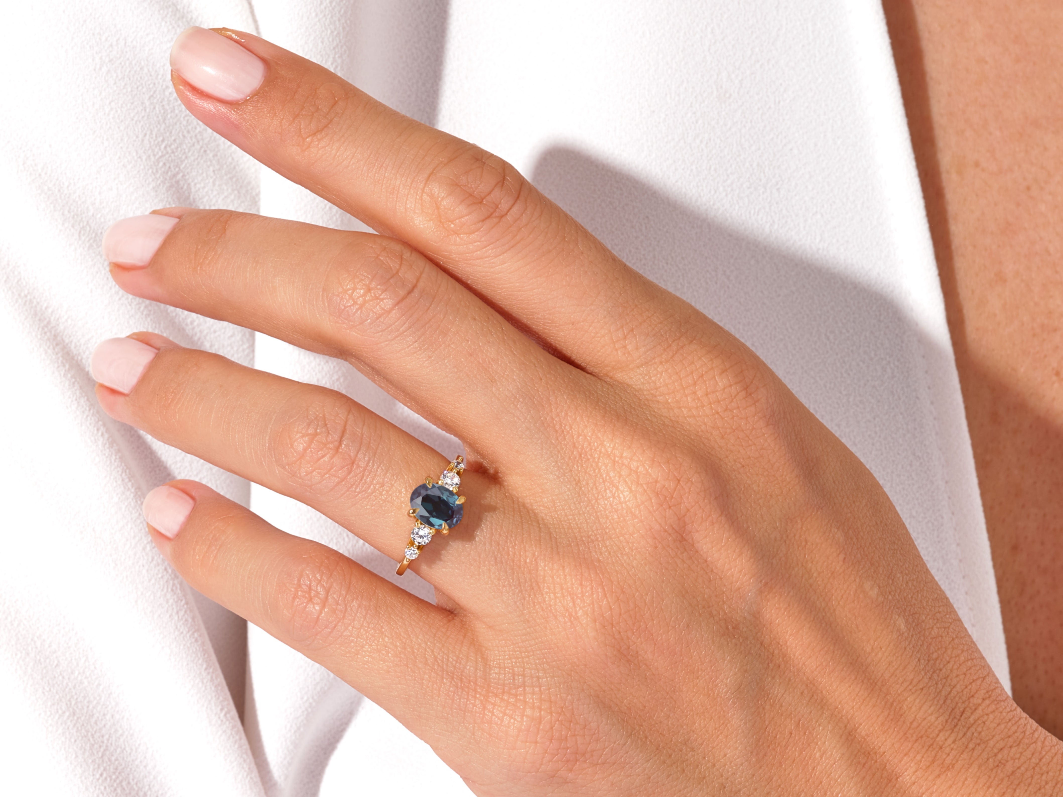 Oval sapphire and diamond engagement ring on hand