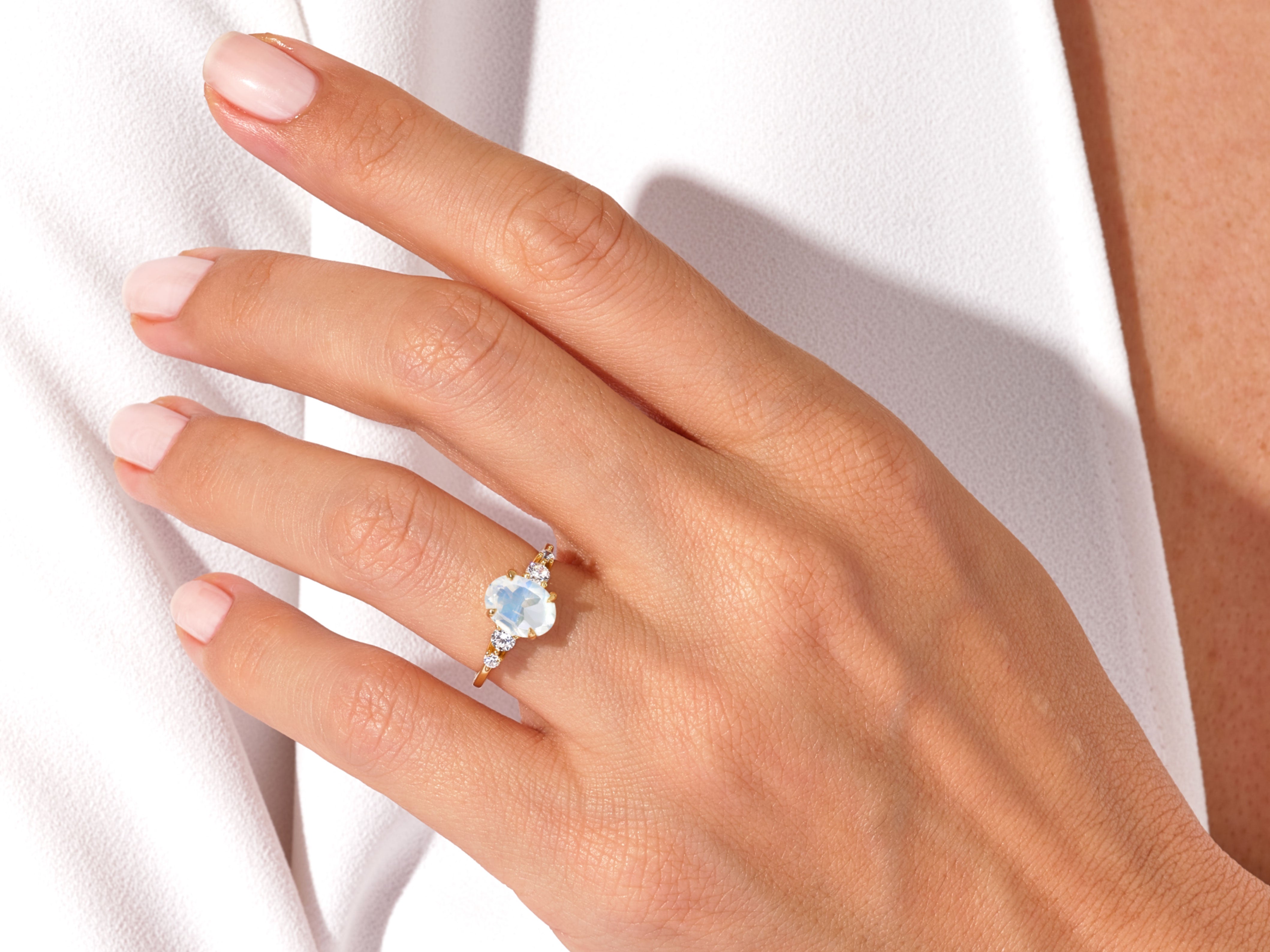 Gold ring with oval moonstone and diamonds on hand