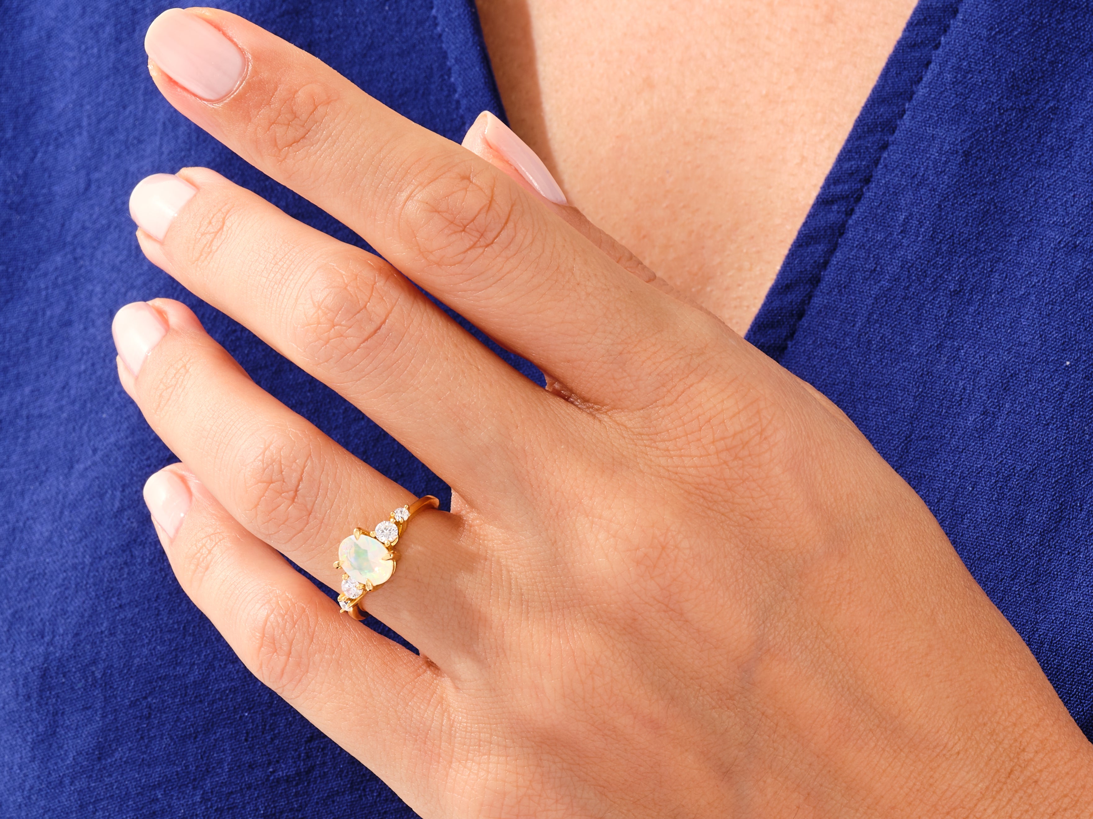 Gold opal and diamond ring on a woman's hand