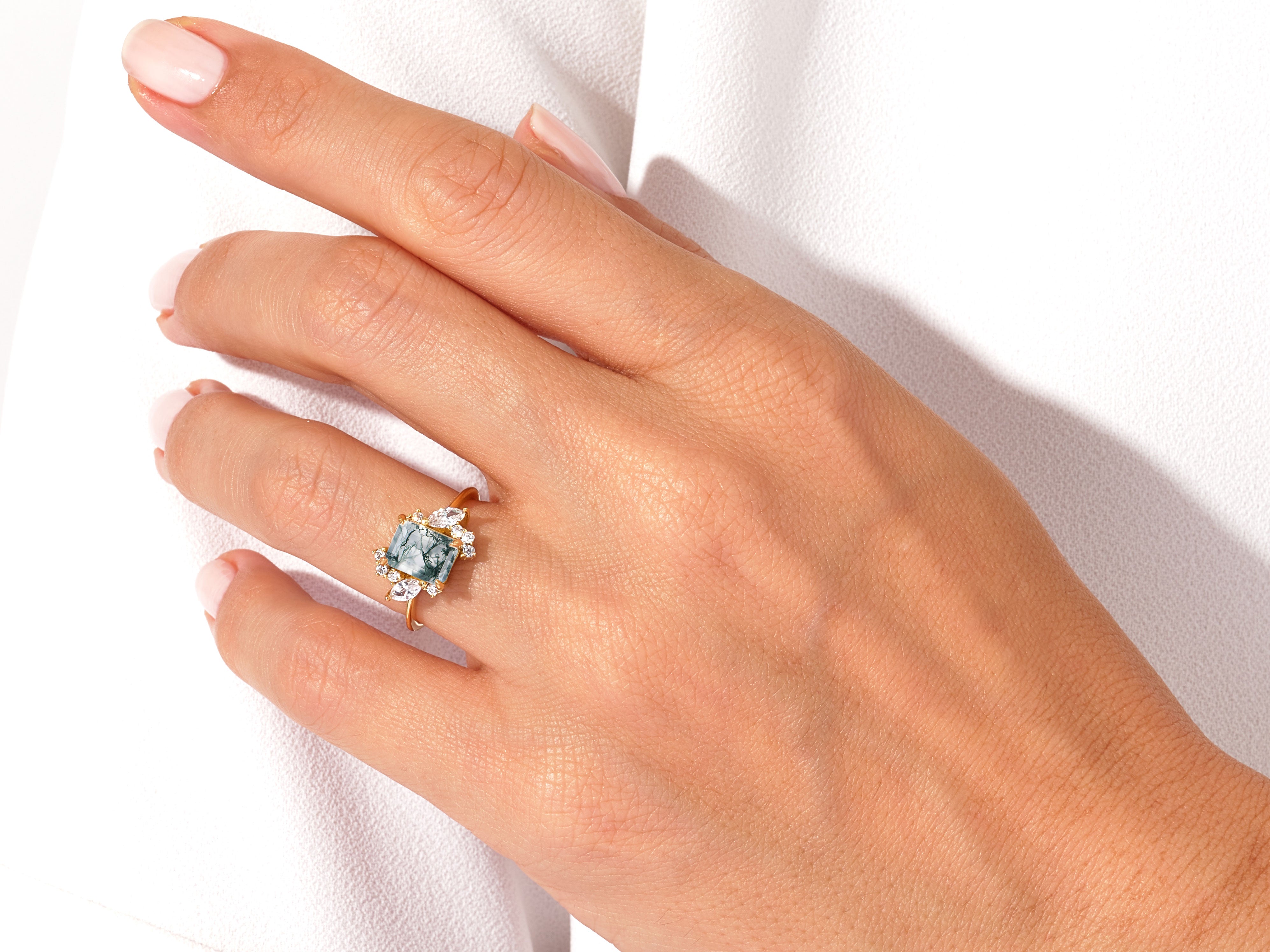 Gold ring with moss agate and diamond accents on hand