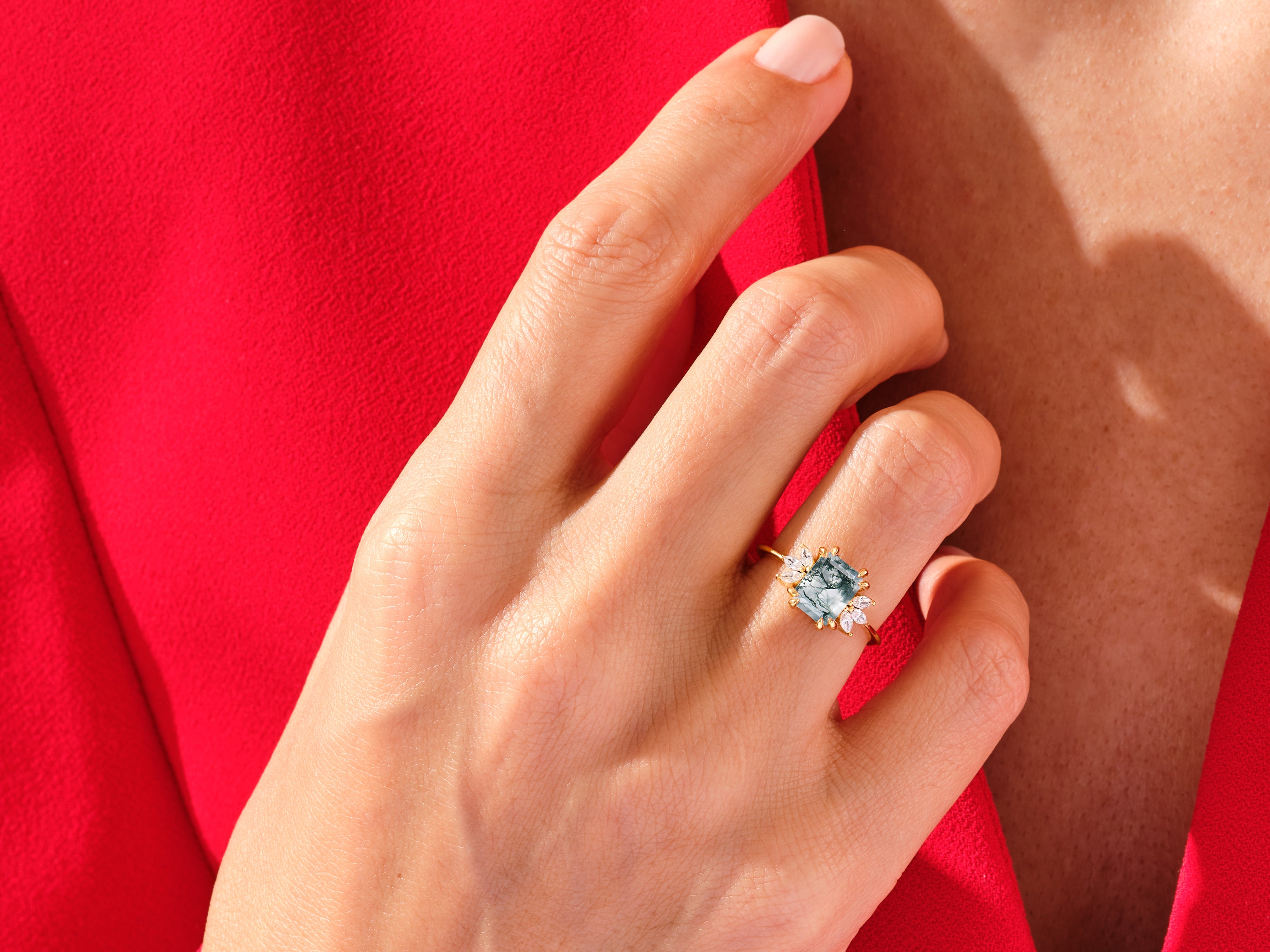Gold ring with moss agate and diamonds on a hand
