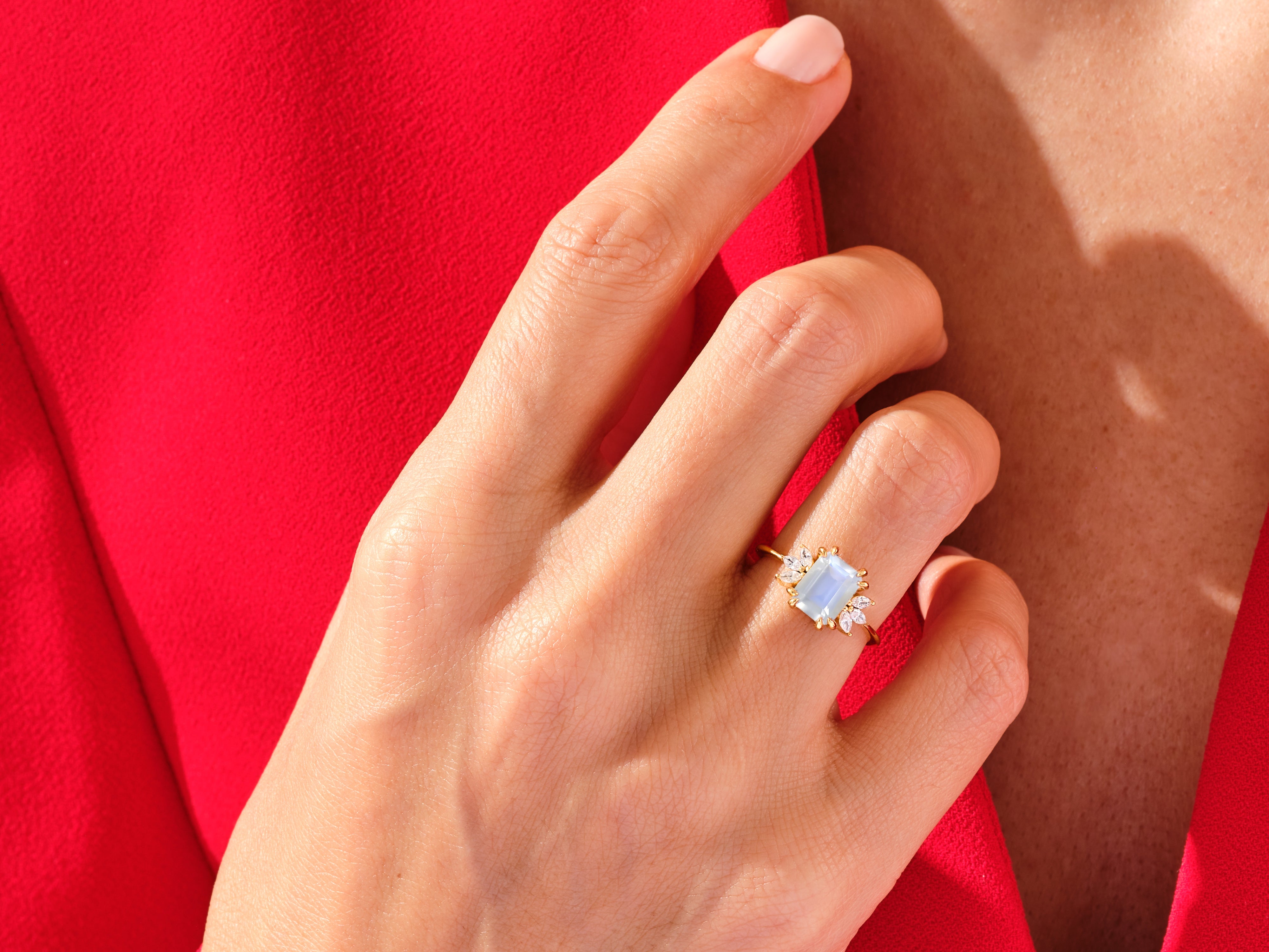 Gold ring with blue gemstone and diamonds on hand