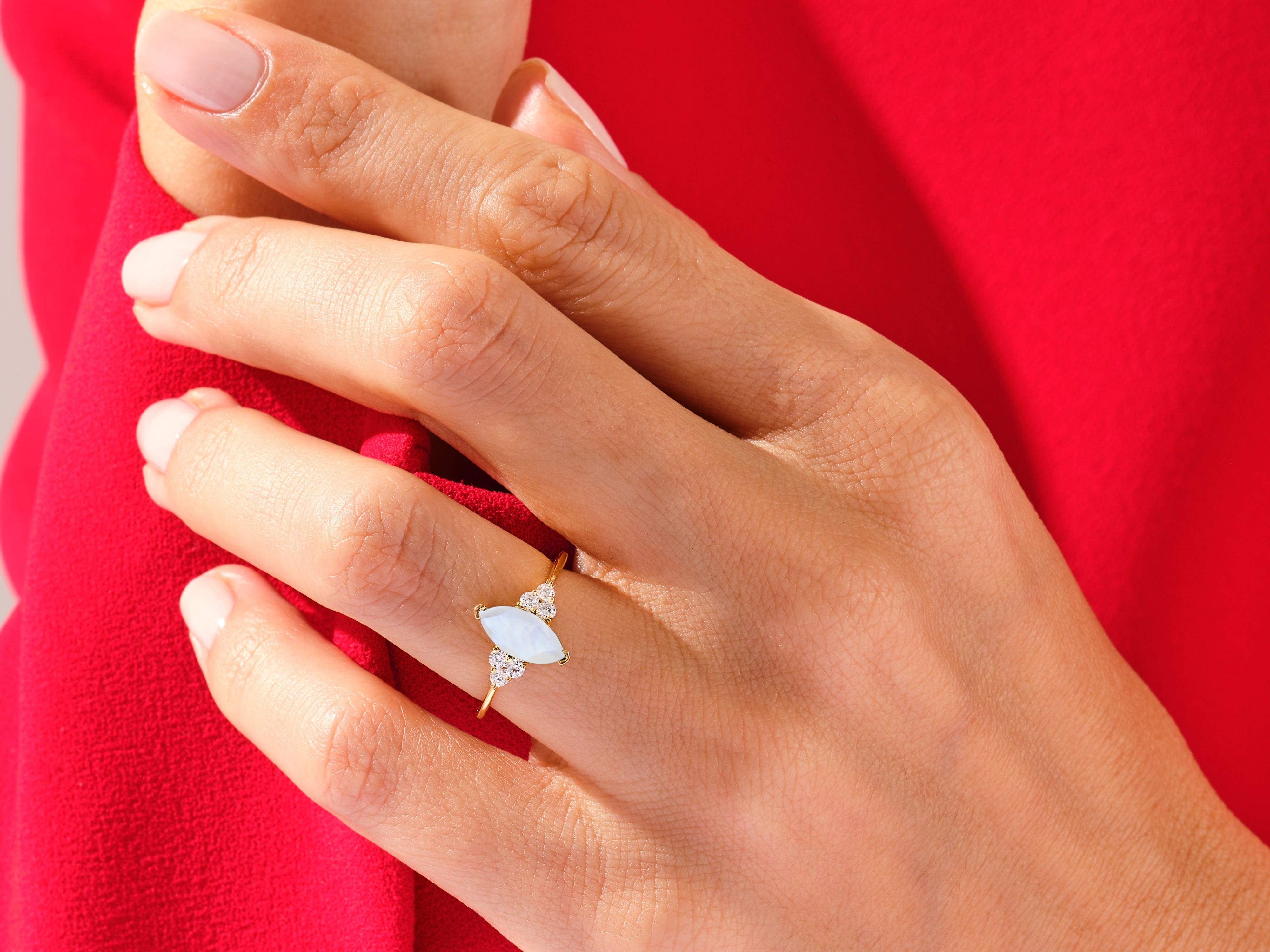 Gold marquise opal and diamond ring on hand