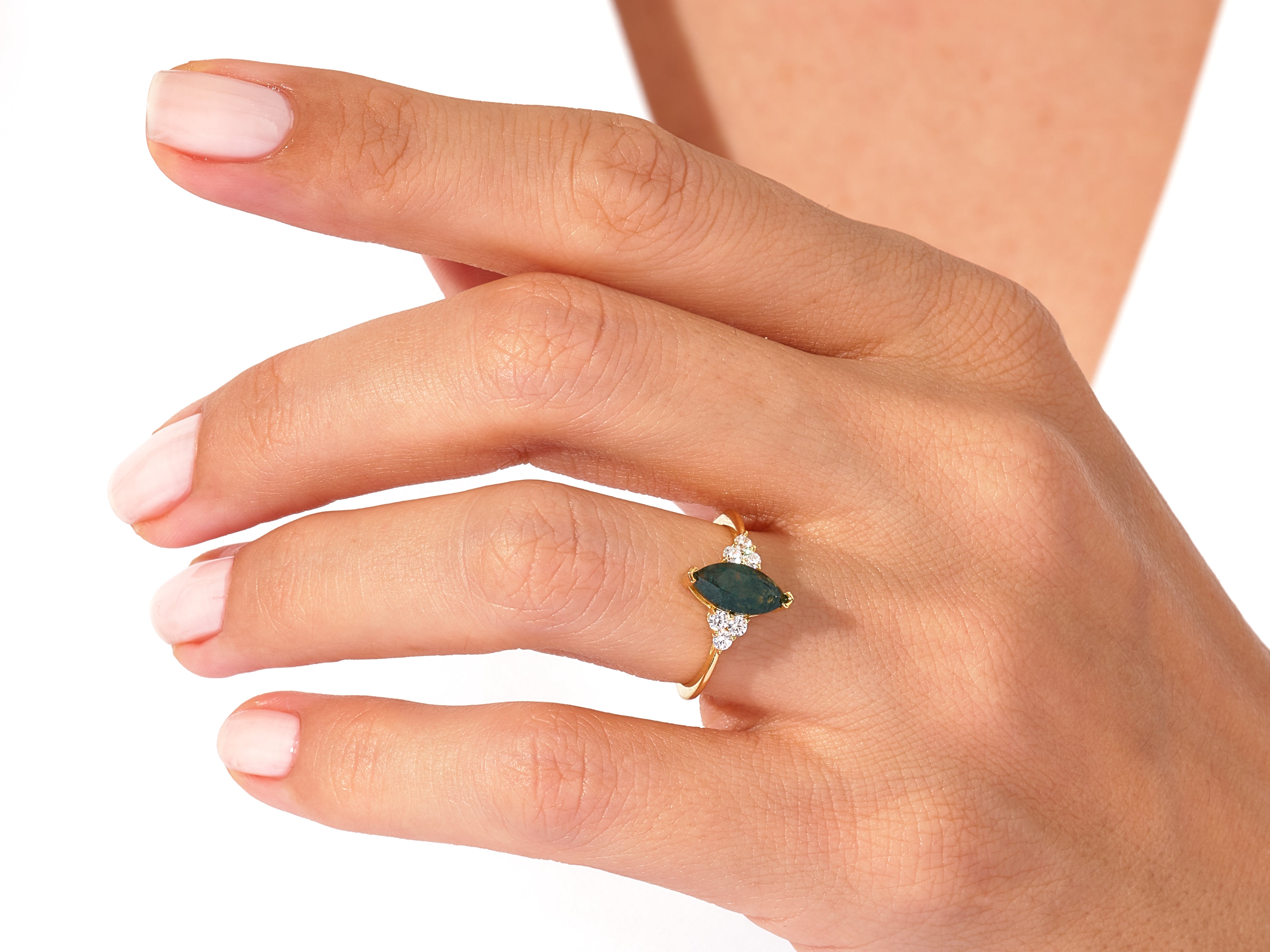 Gold marquise ring with green stone and diamonds on hand