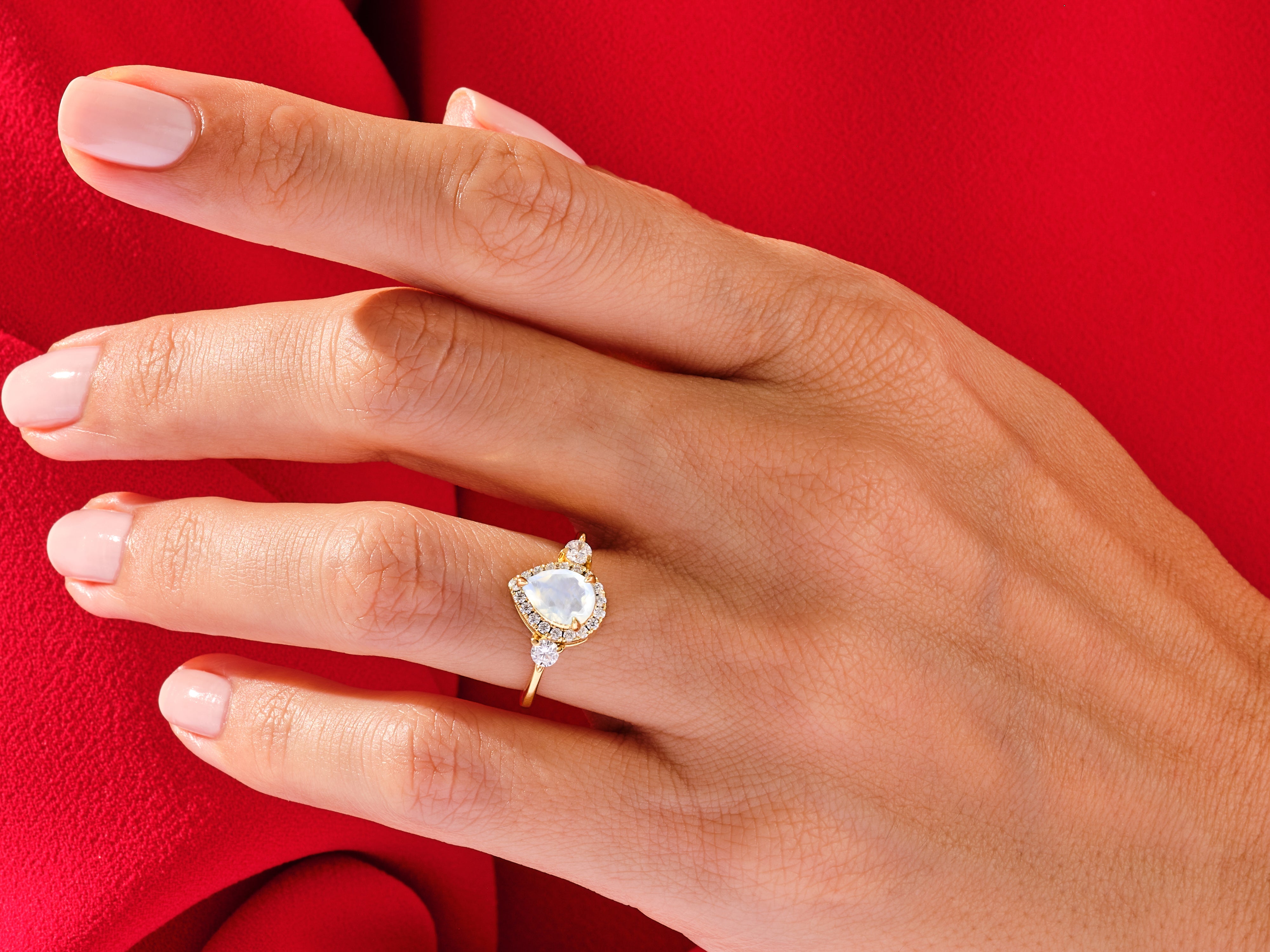 Gold ring with pear-shaped moonstone and diamonds on hand