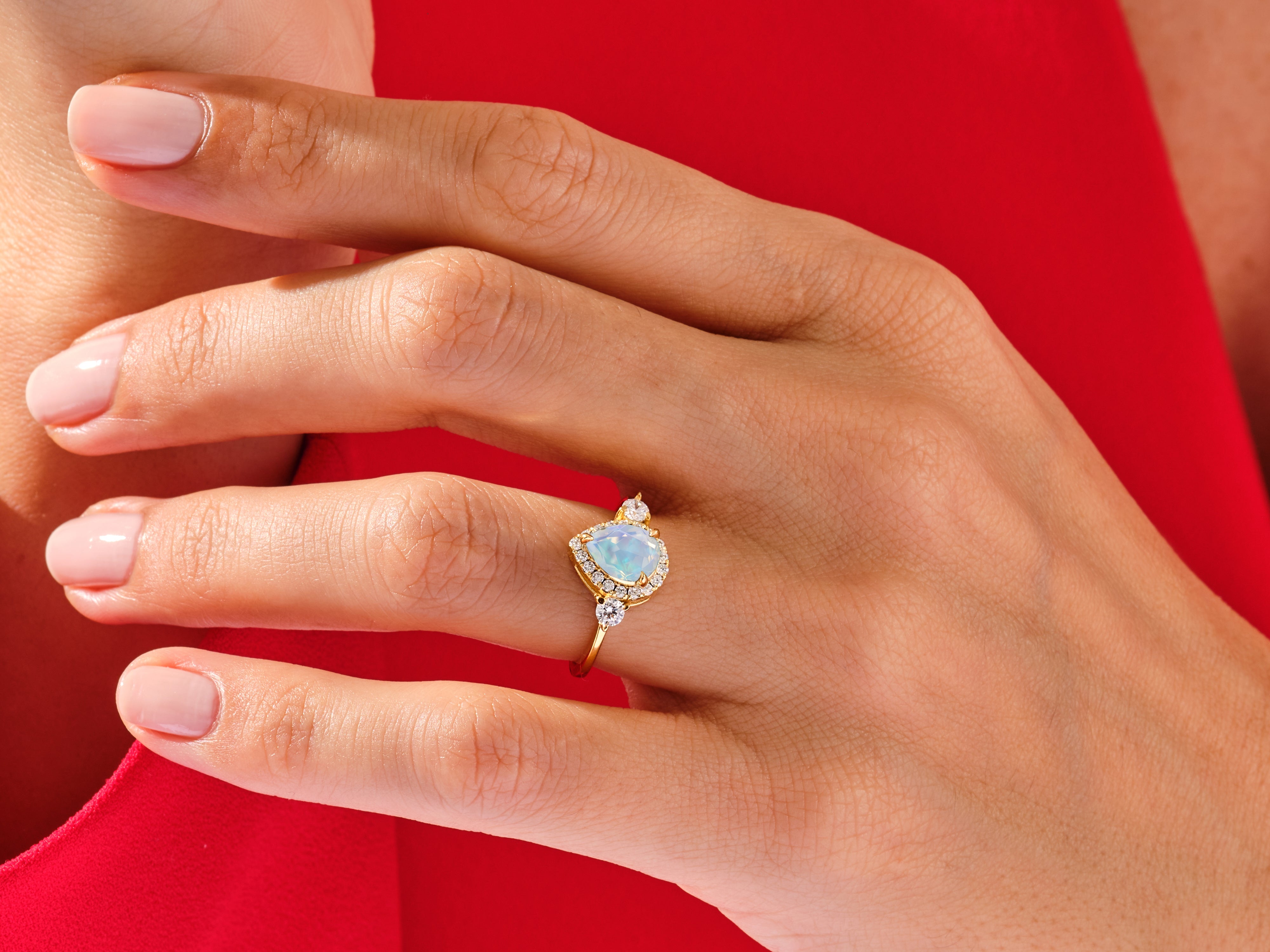 Gold opal diamond ring on a hand