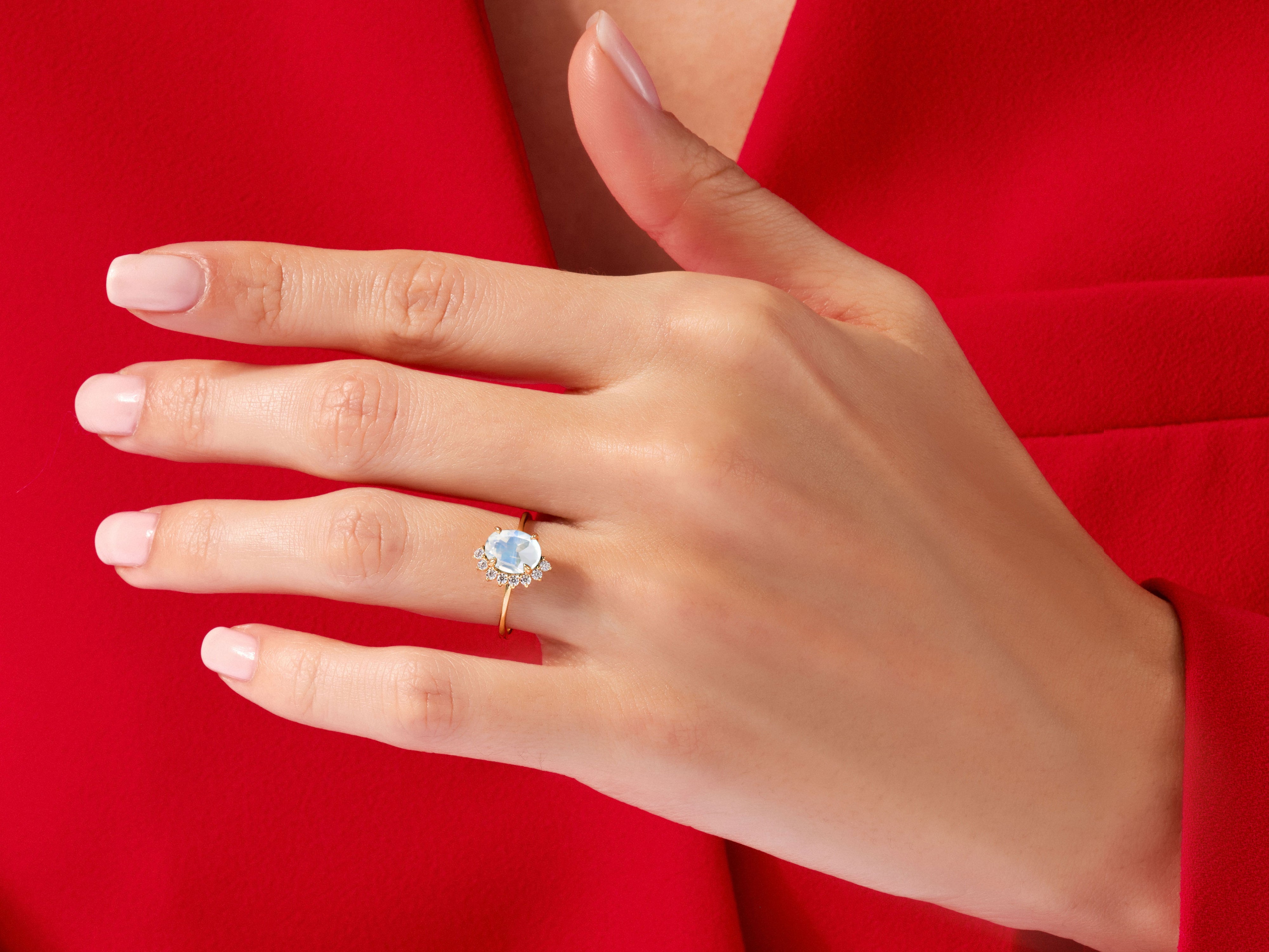 Gold ring with moonstone and diamonds on a hand