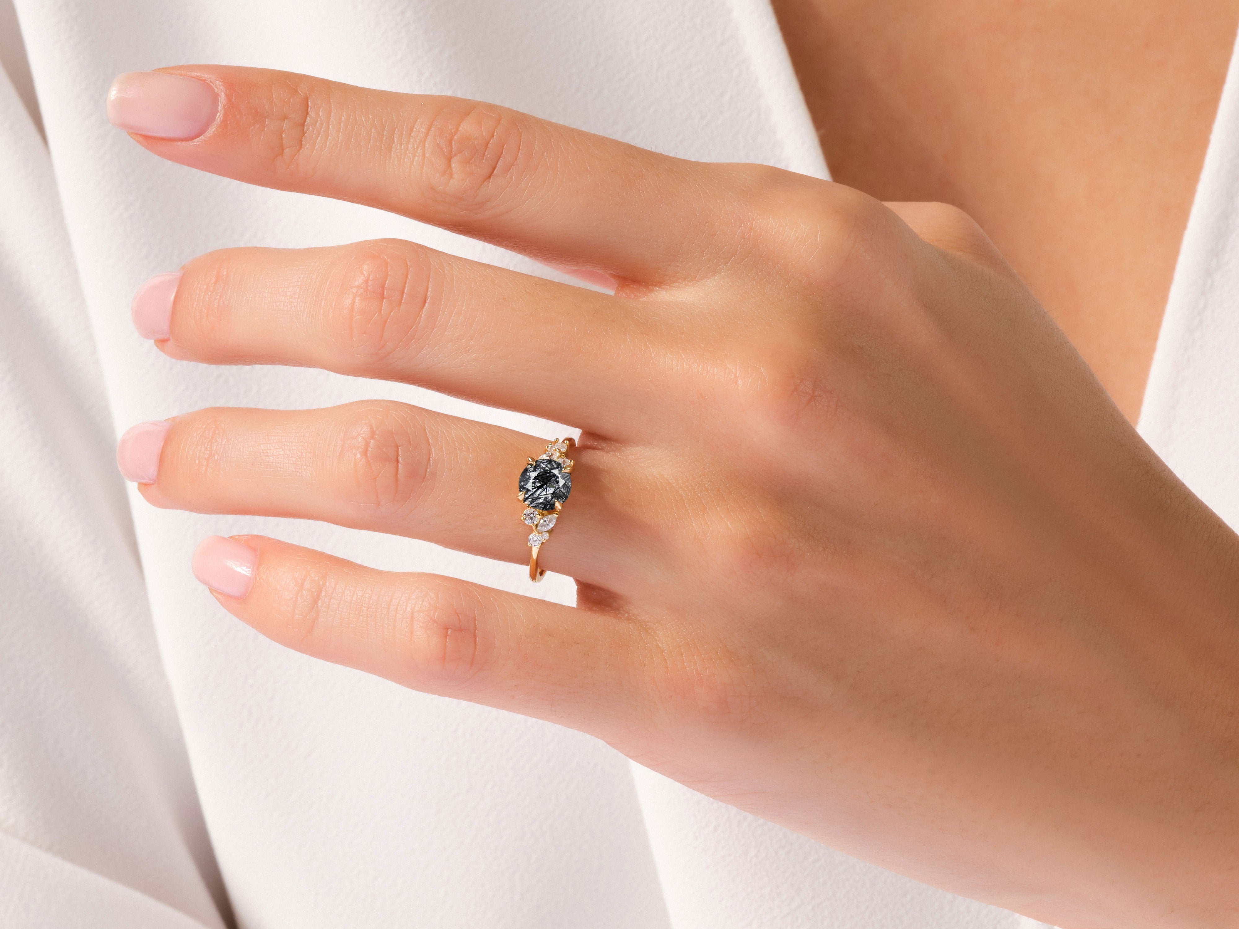 Gold ring with black diamond and white stones on a woman's hand