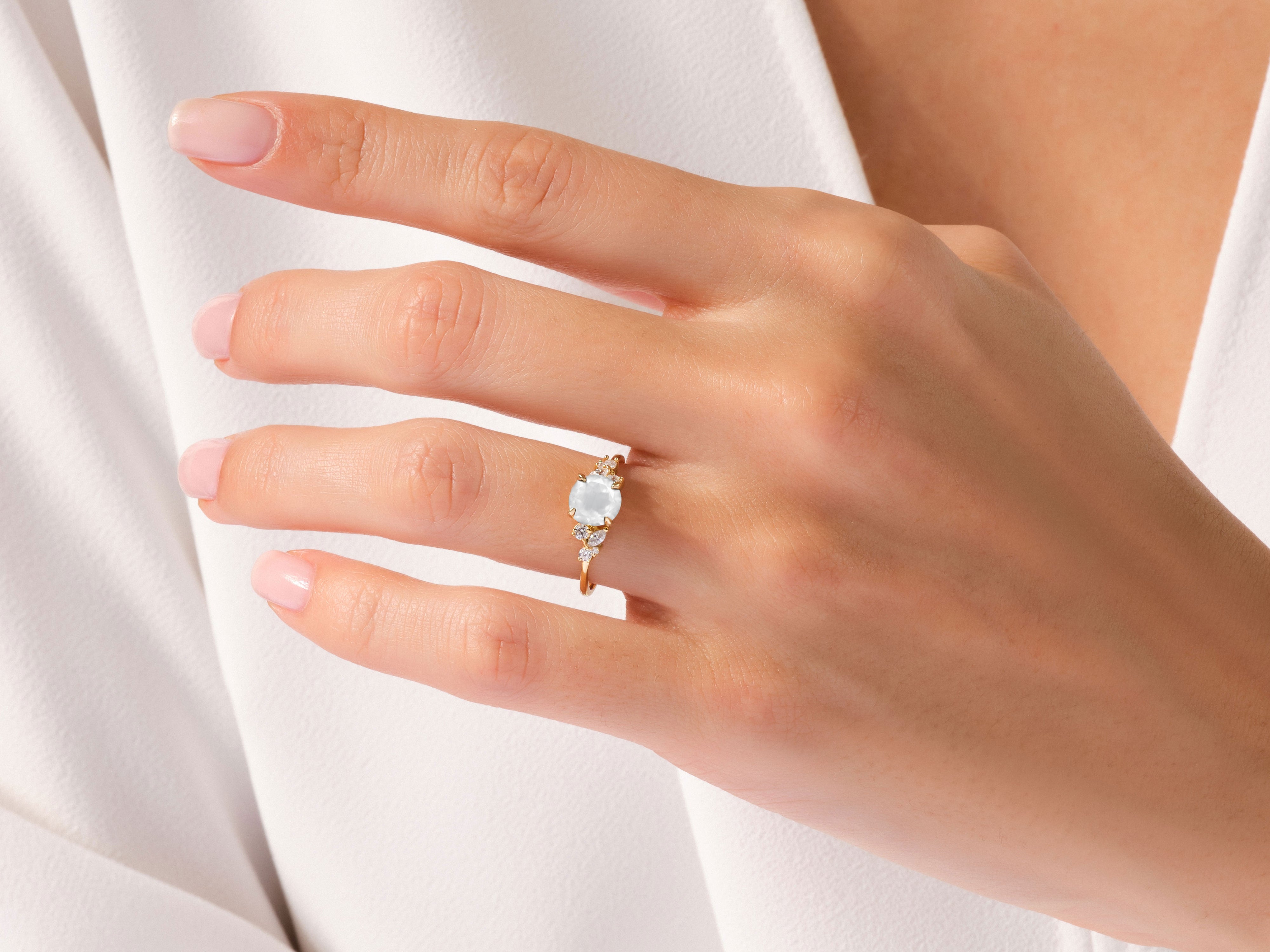 Gold ring with opal and diamonds on a woman's hand