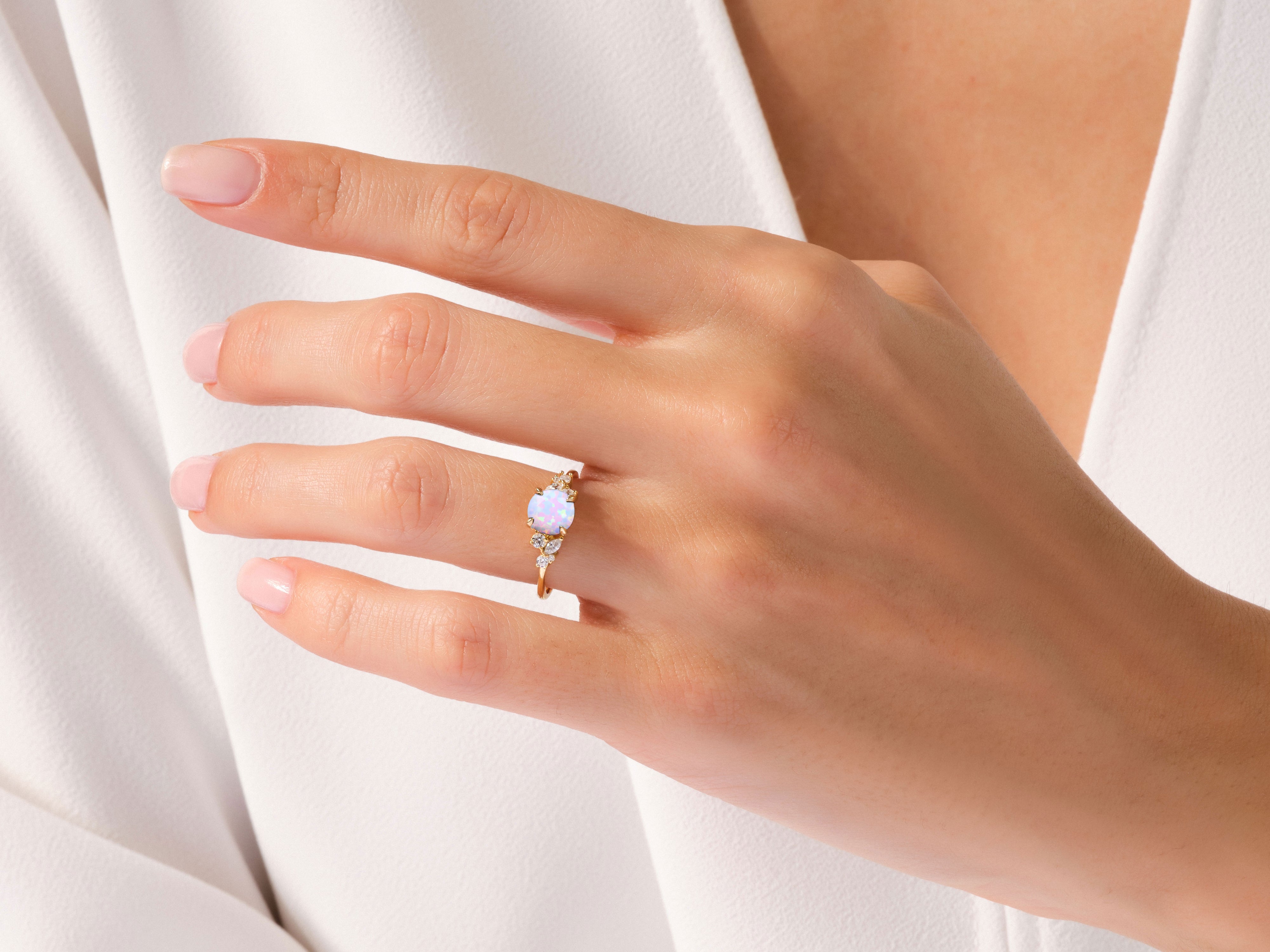 Gold opal ring with diamonds on a woman's hand