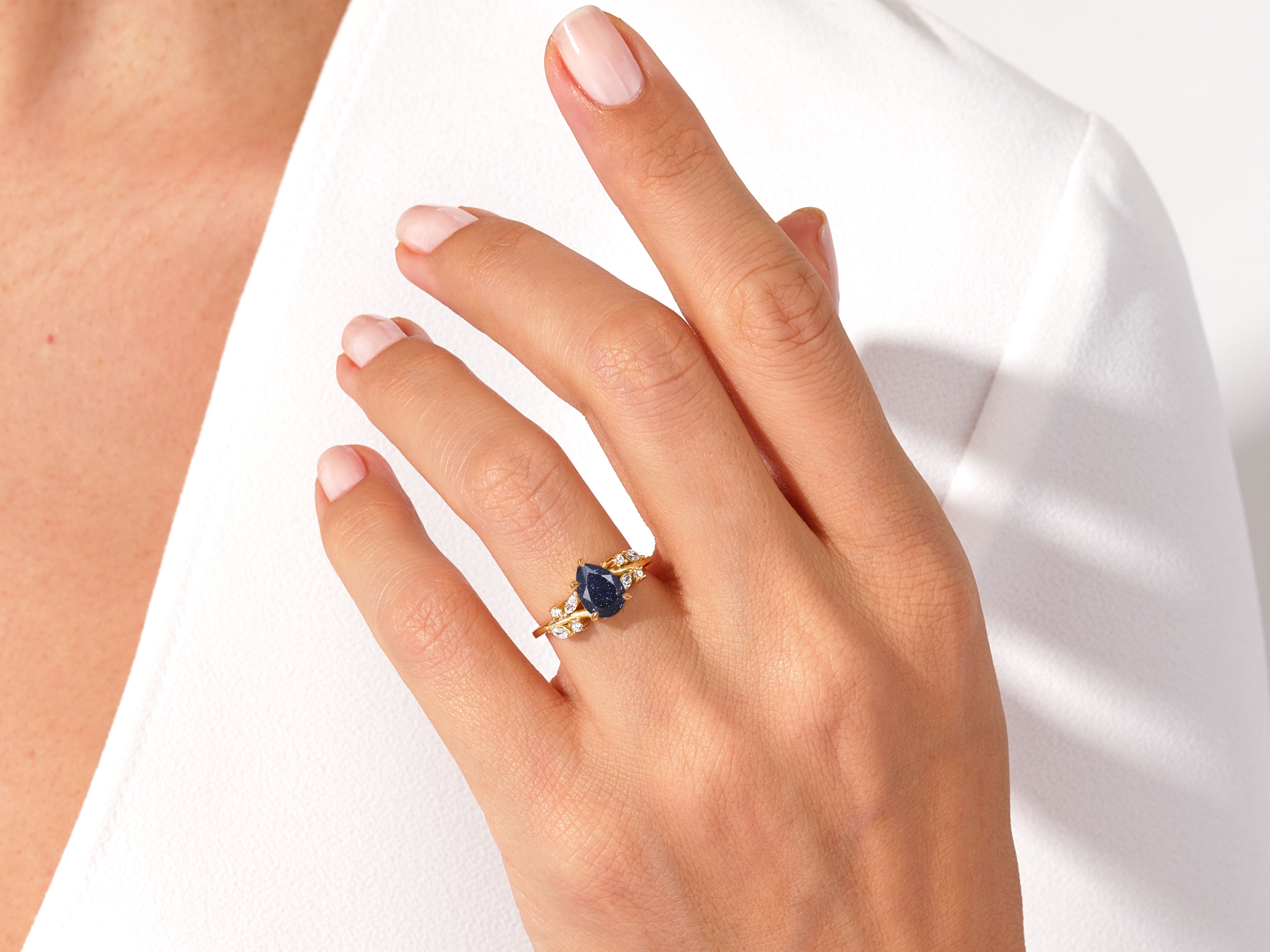Gold ring with pear-shaped blue sapphire and diamonds