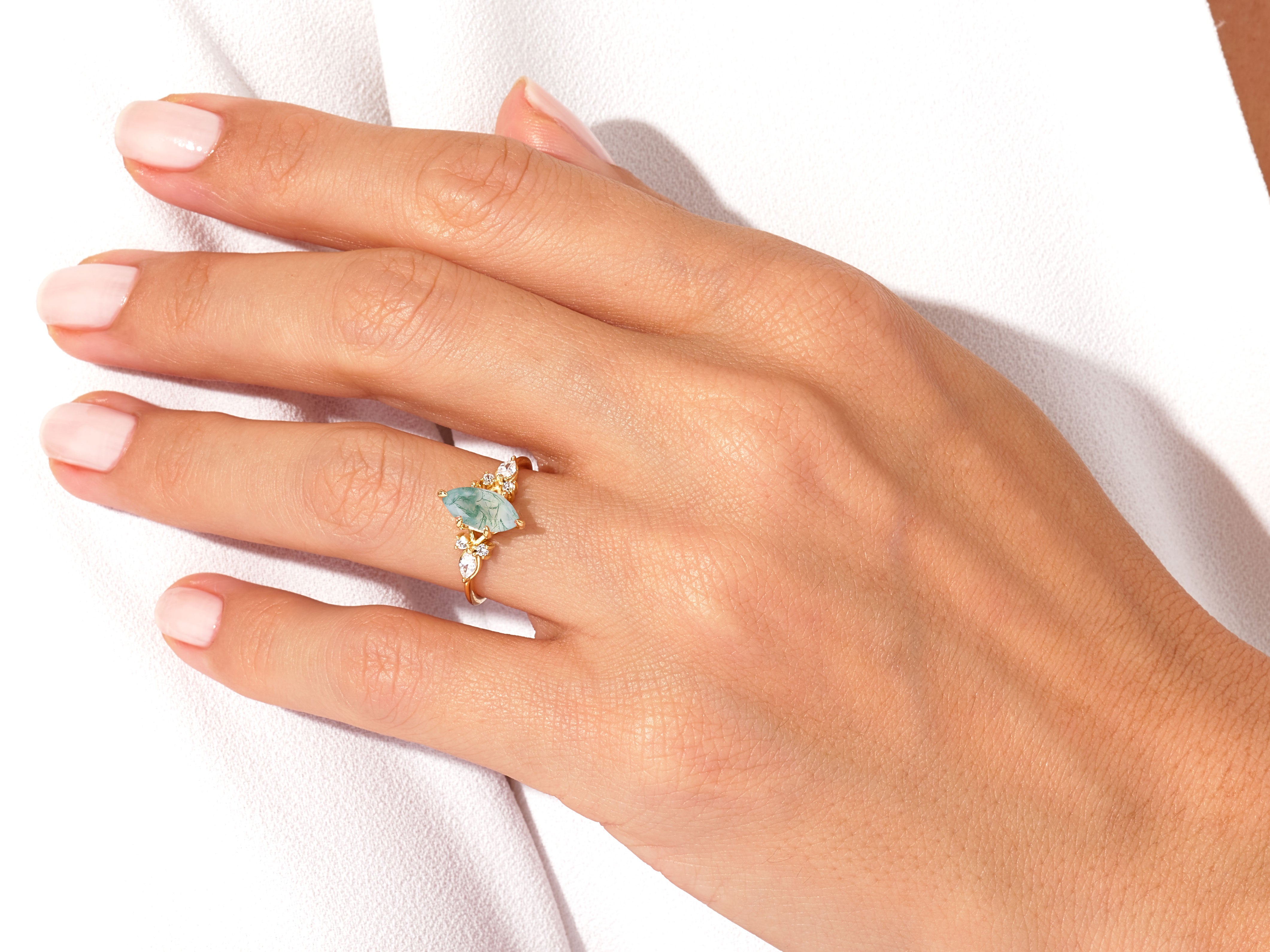 Gold ring with marquise moss agate and diamond accents on hand