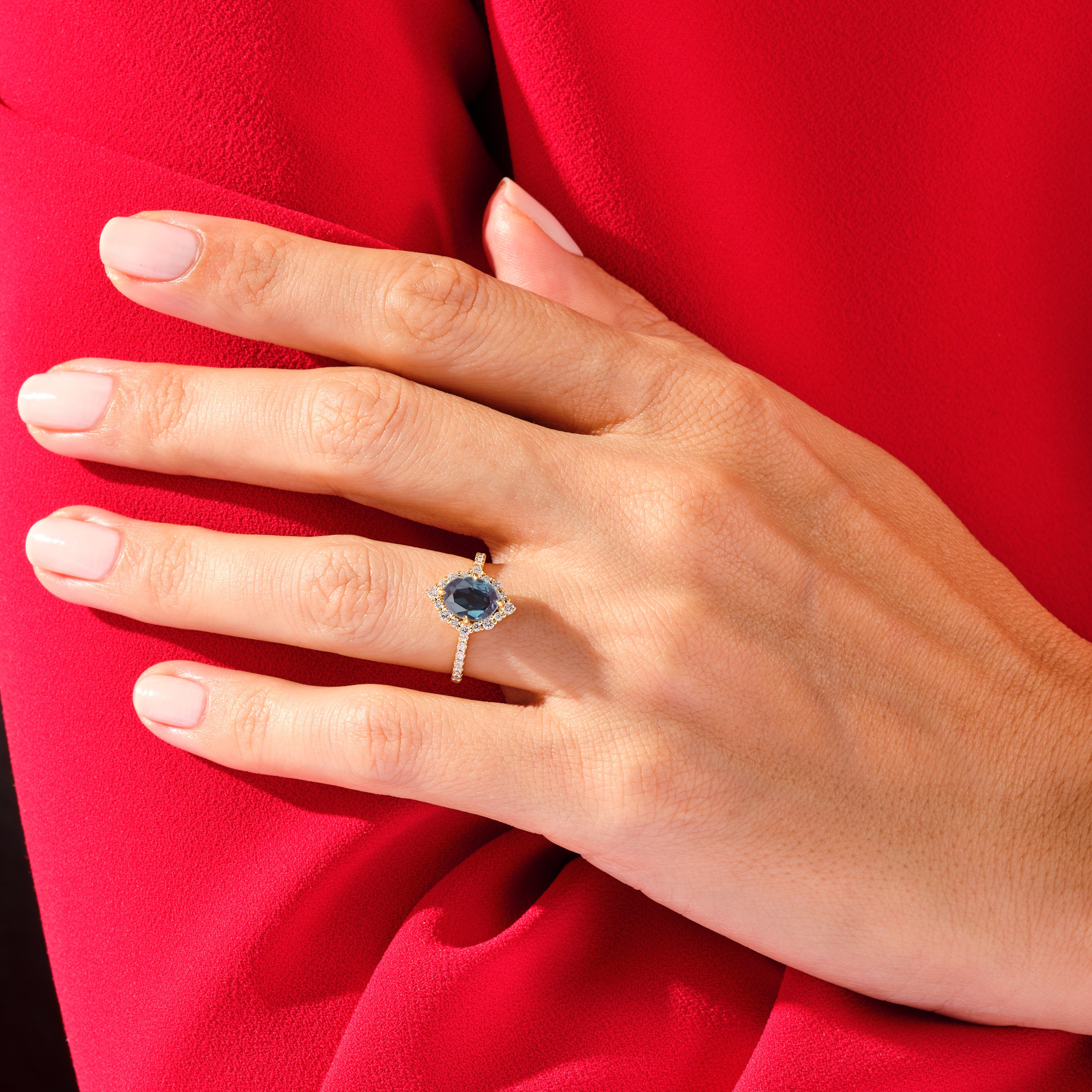 Gold sapphire diamond halo engagement ring on hand