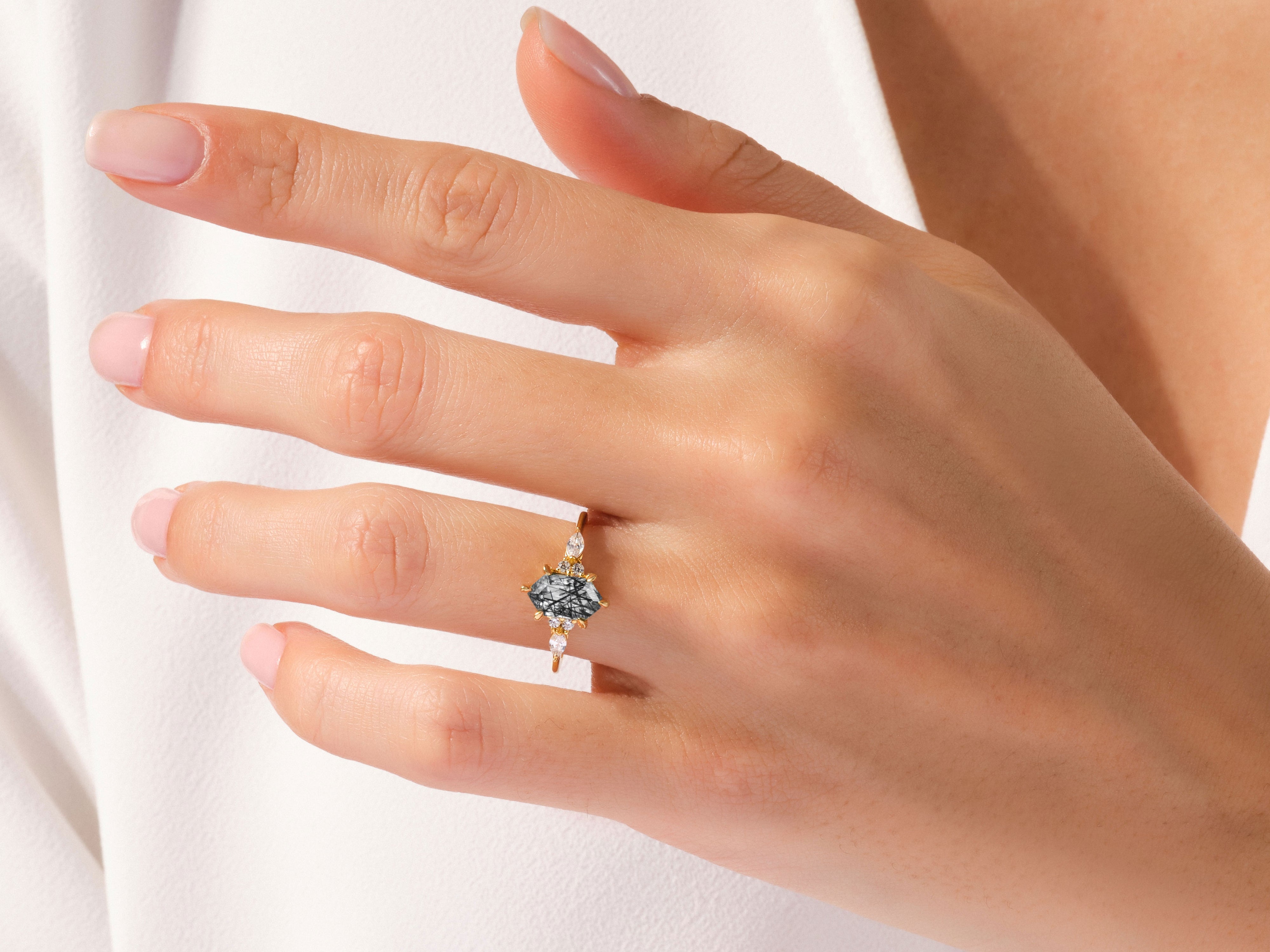 Gold ring with unique gemstone and diamonds on a hand