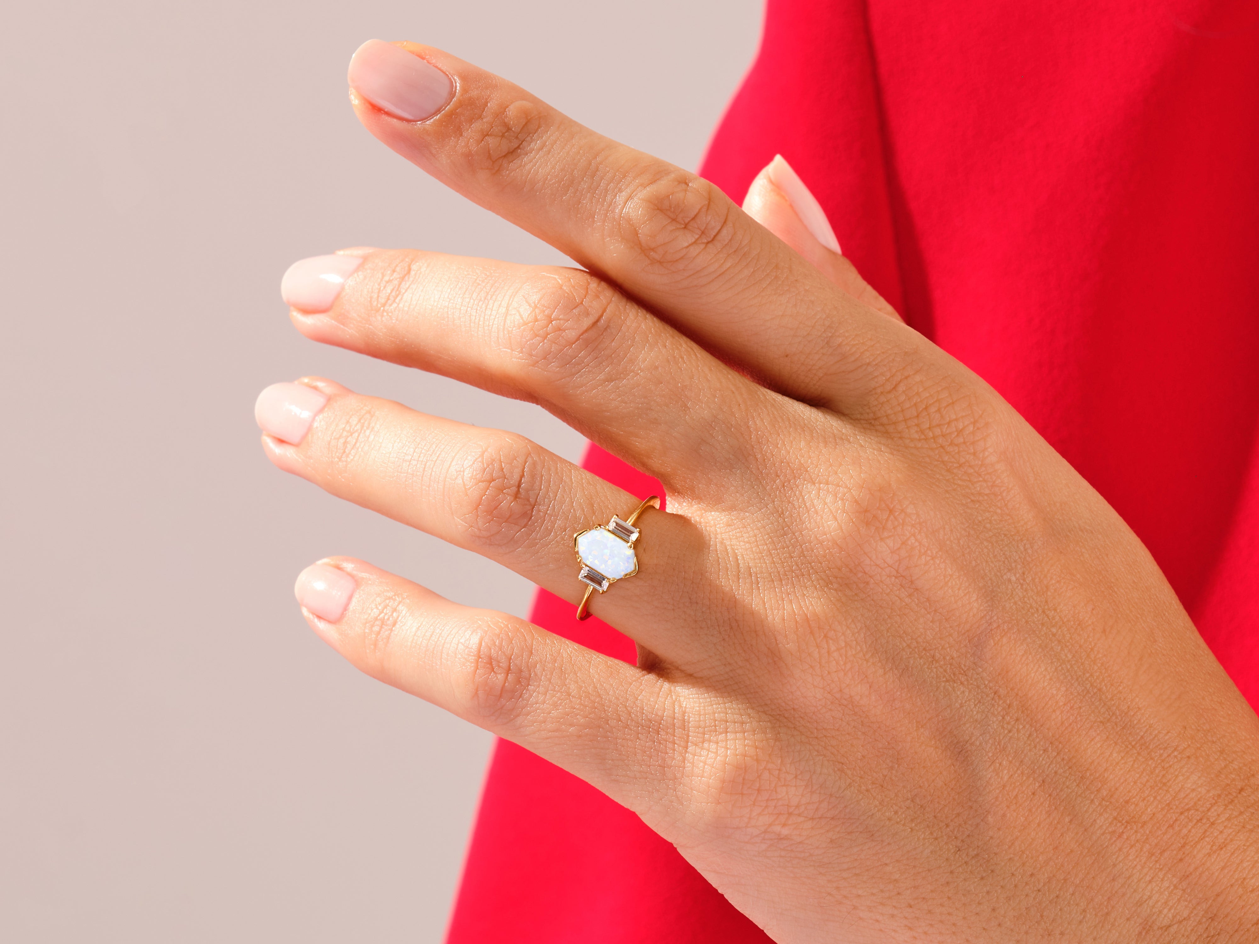 Gold ring with opal and baguette diamonds on a hand