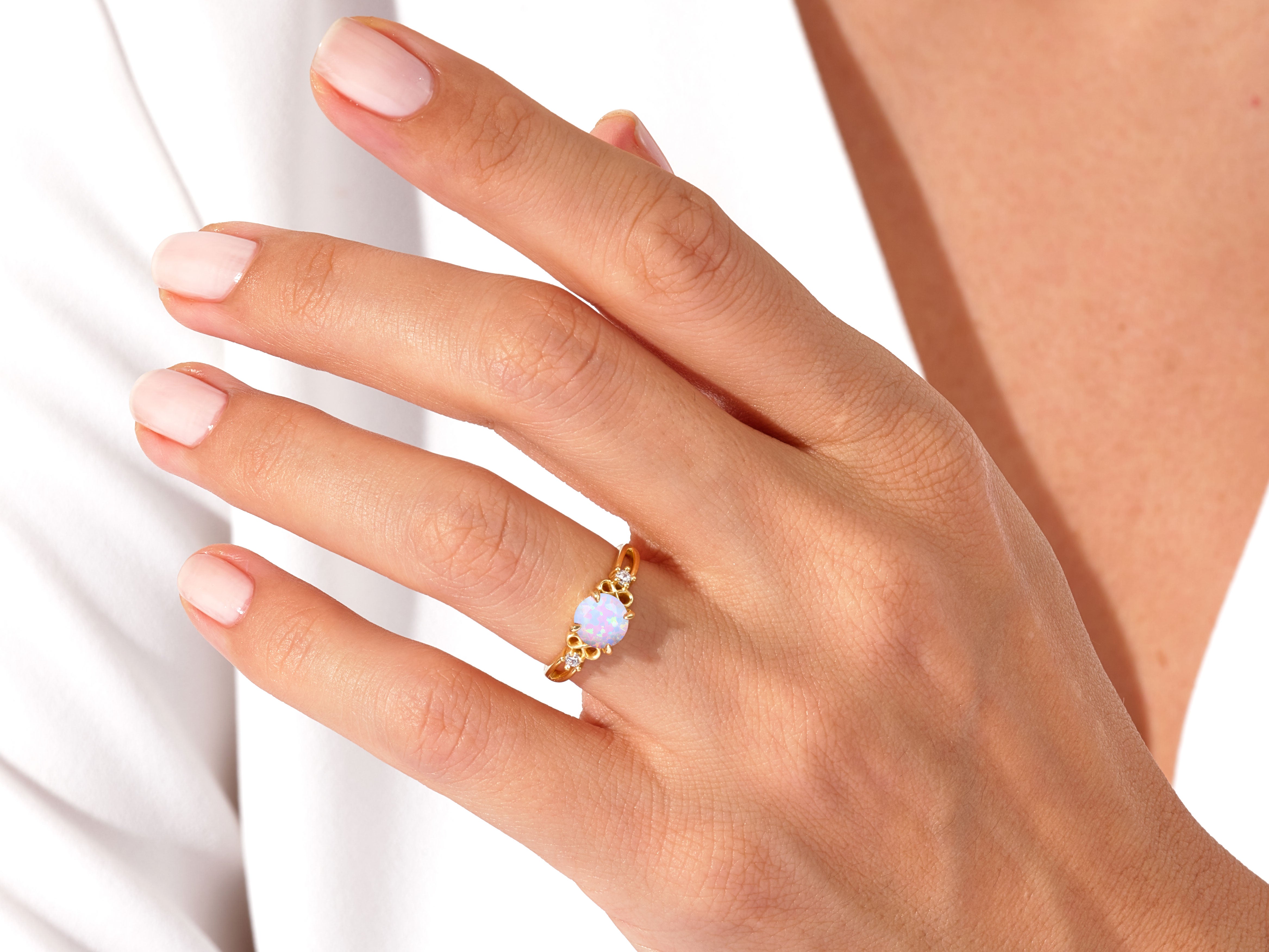 Gold opal ring with diamonds on a woman's hand