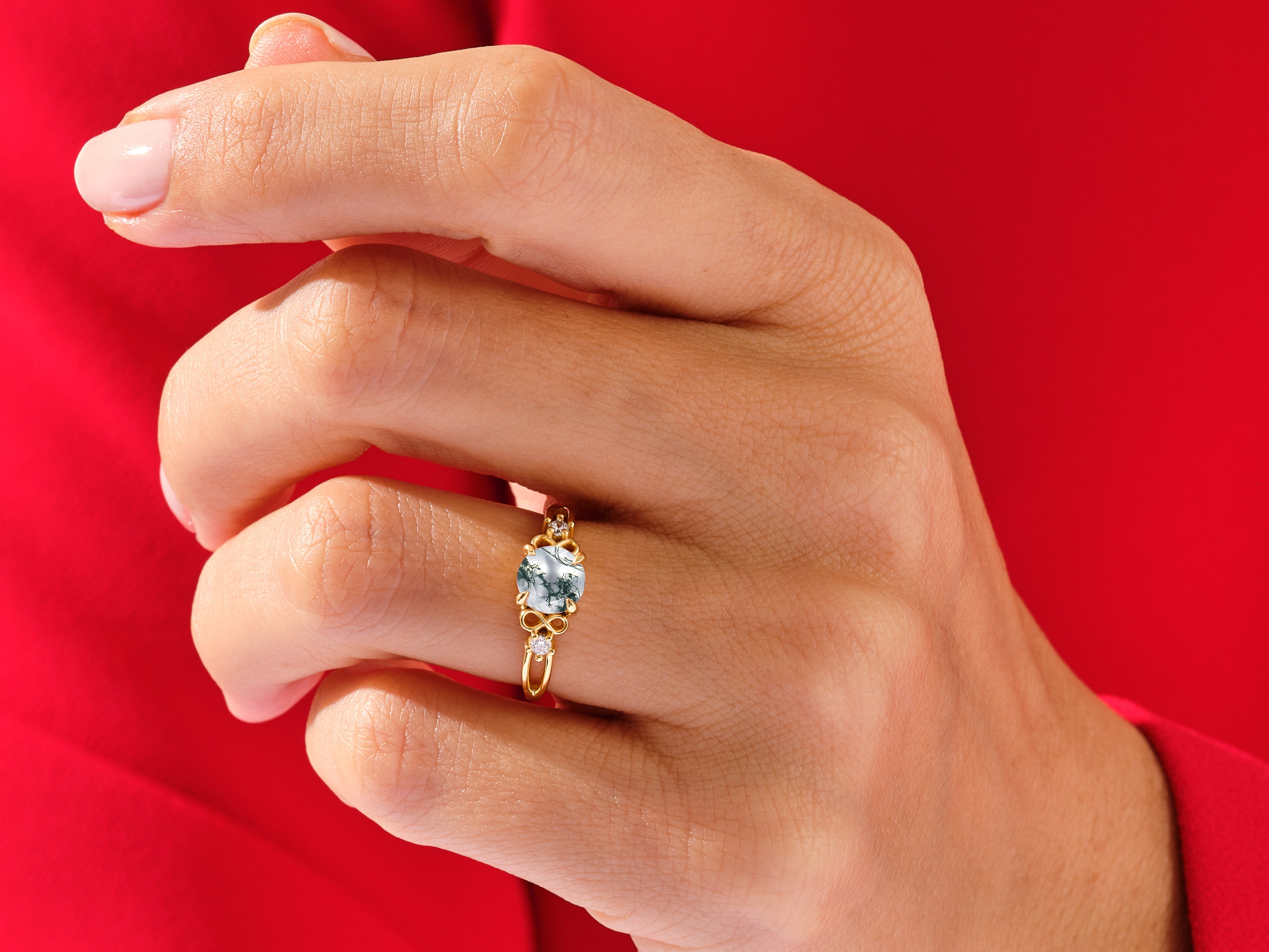 Gold ring with moss agate and diamonds on a hand