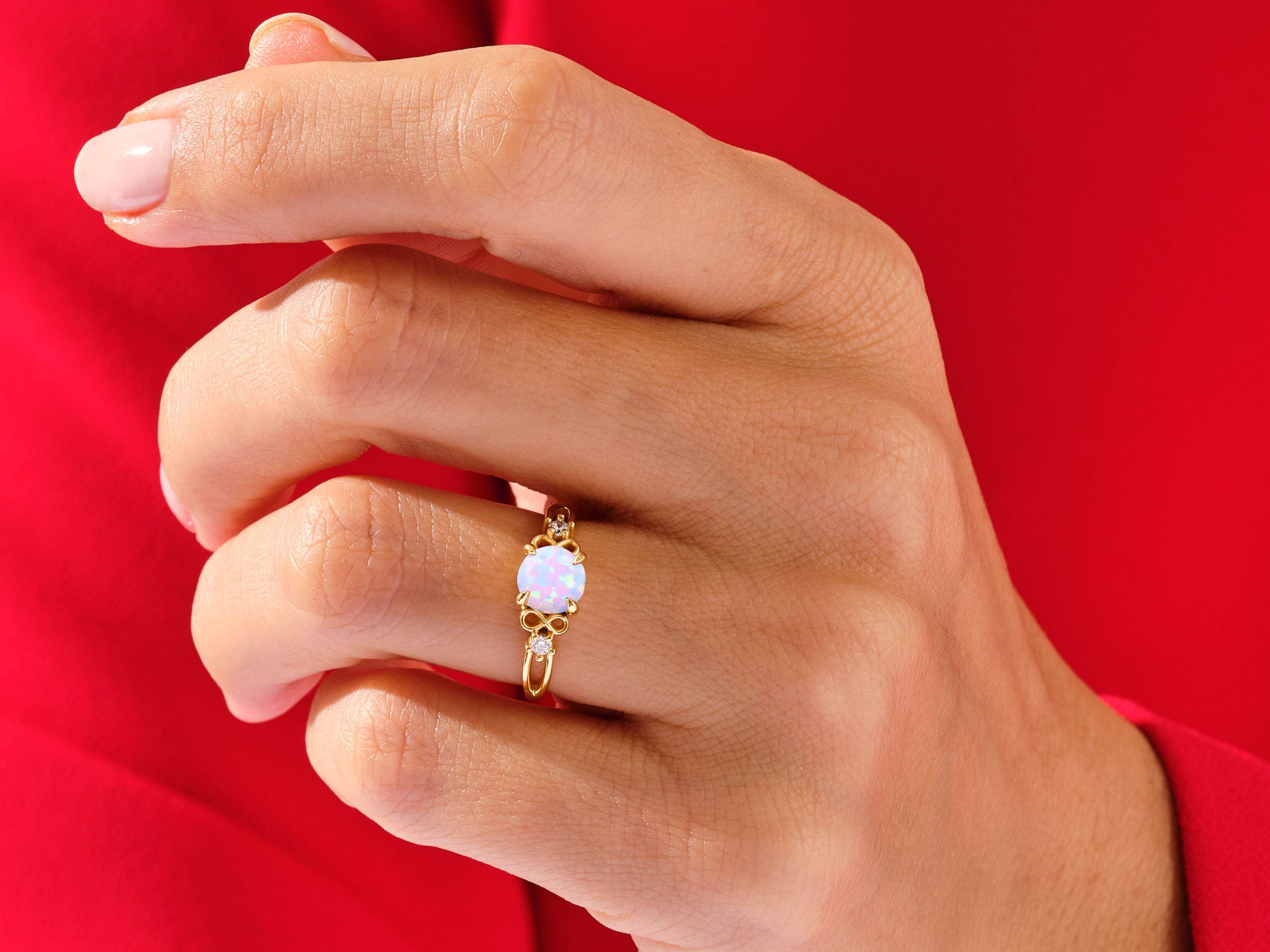 Gold opal ring with diamonds on a hand