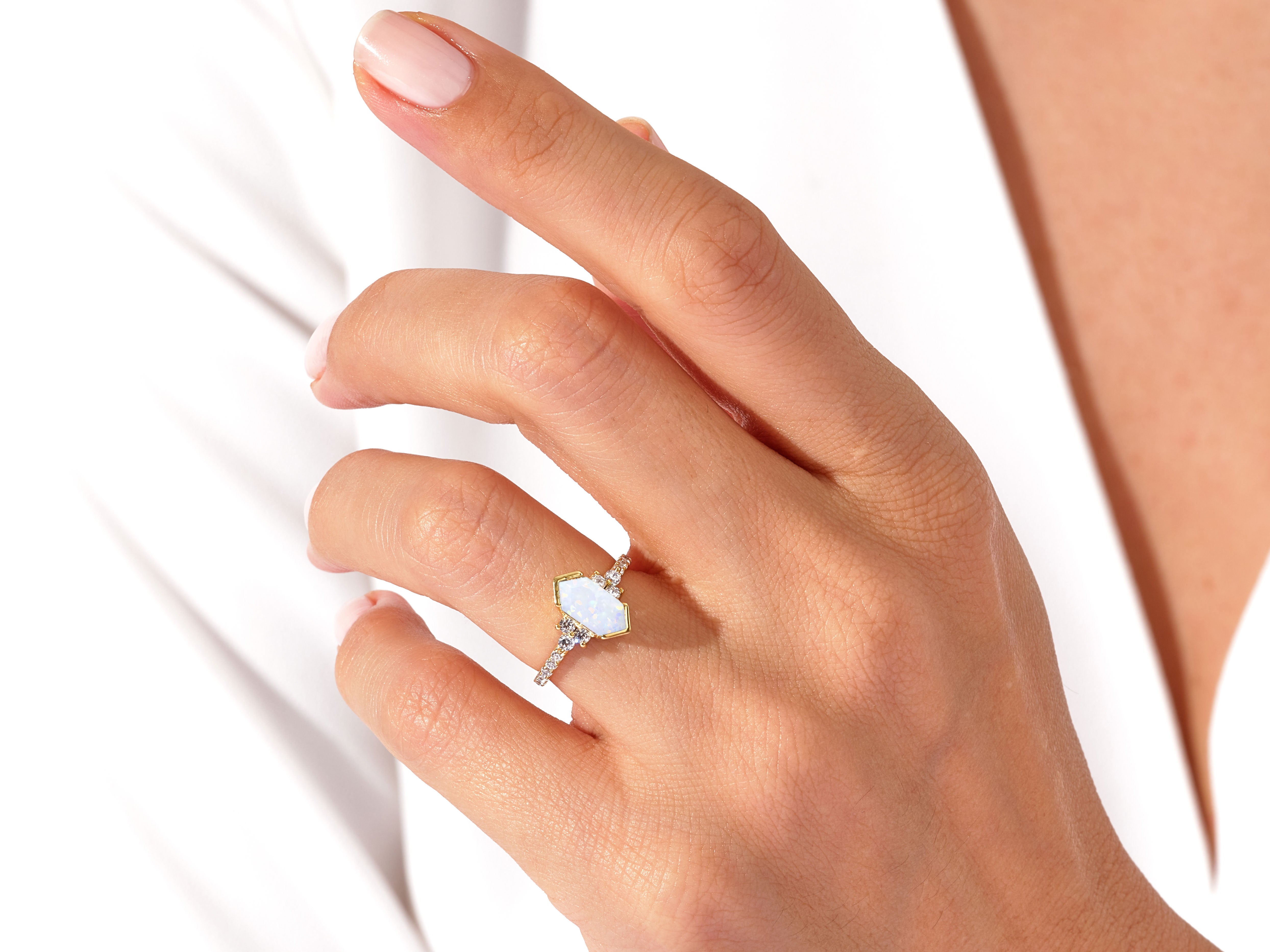 Gold opal ring with diamonds on a hand